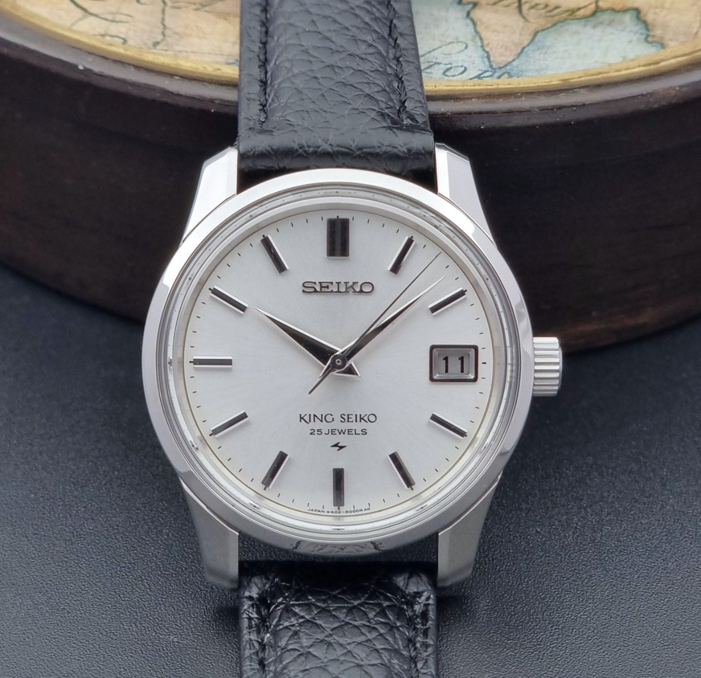 Vintage King Seiko Wristwatch 4402-8000 on a black leather strap on a dark background dial close up