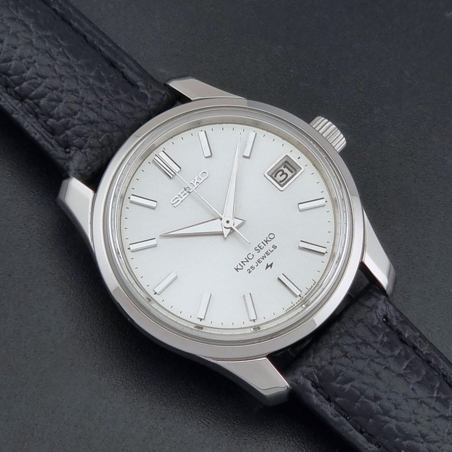 Vintage King Seiko 4402-8000 Wristwatch with a white dial on a dark background close up dial view
