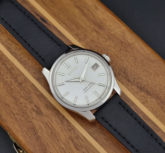 Vintage King Seiko 4402-8000 Wristwatch with black strap and silver case on a wooden surface