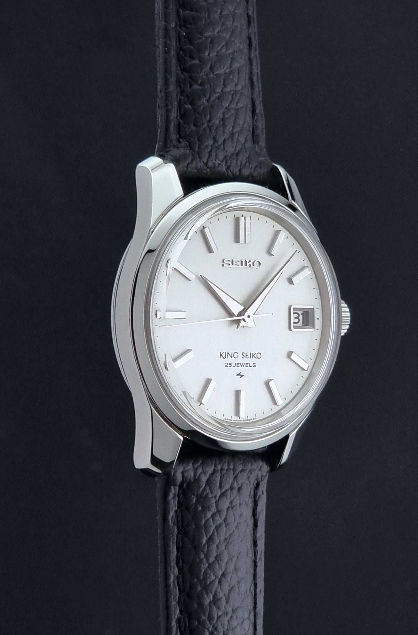 Vintage King Seiko 4402-8000 Wristwatch with a white dial on a dark background side profile view