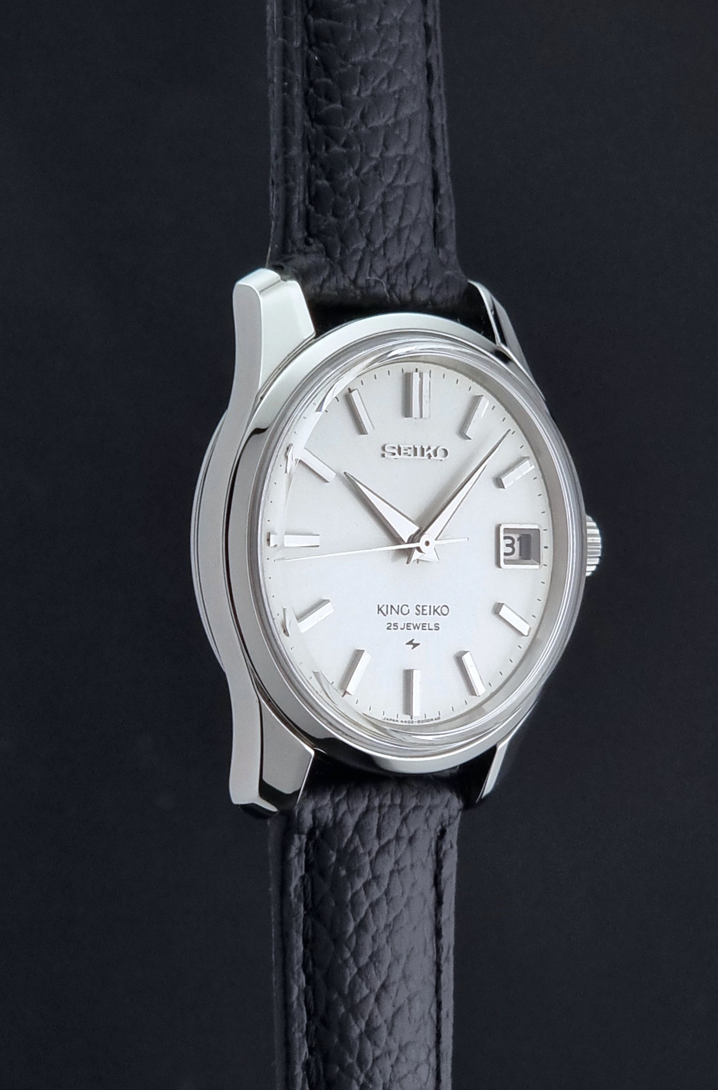 Vintage King Seiko 4402-8000 Wristwatch with a white dial on a dark background side profile view