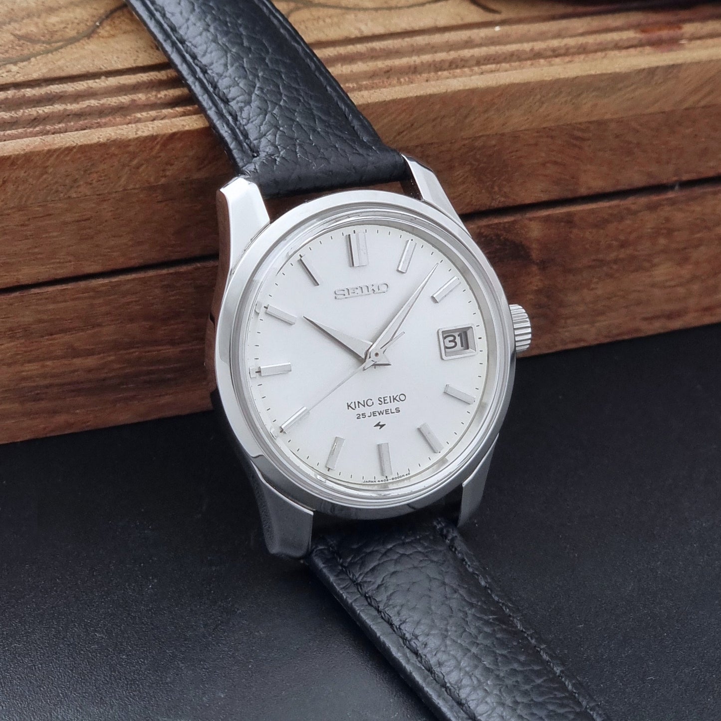 Vintage King Seiko 4402-8000 Wristwatch with a white dial on a dark background side view