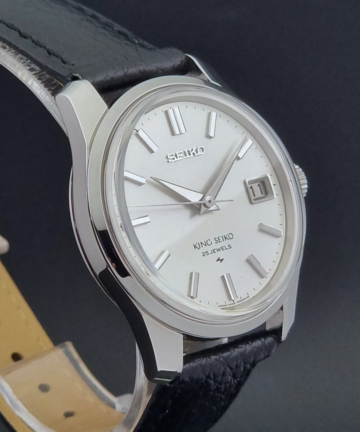 Vintage King Seiko Wristwatch 4402-8000 on a black leather strap on a dark background side