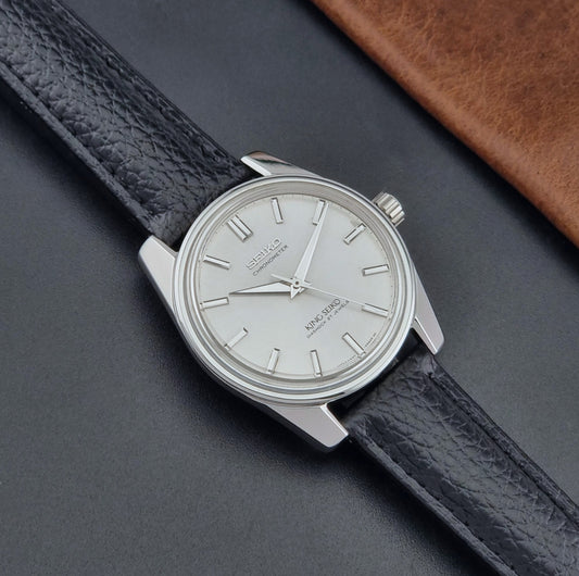 Vintage King Seiko Wristwatch 4420-9990 black leather strap and silver case on a dark surface dial