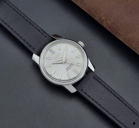 Vintage King Seiko Wristwatch 44999  with a black leather strap on a dark surface dial