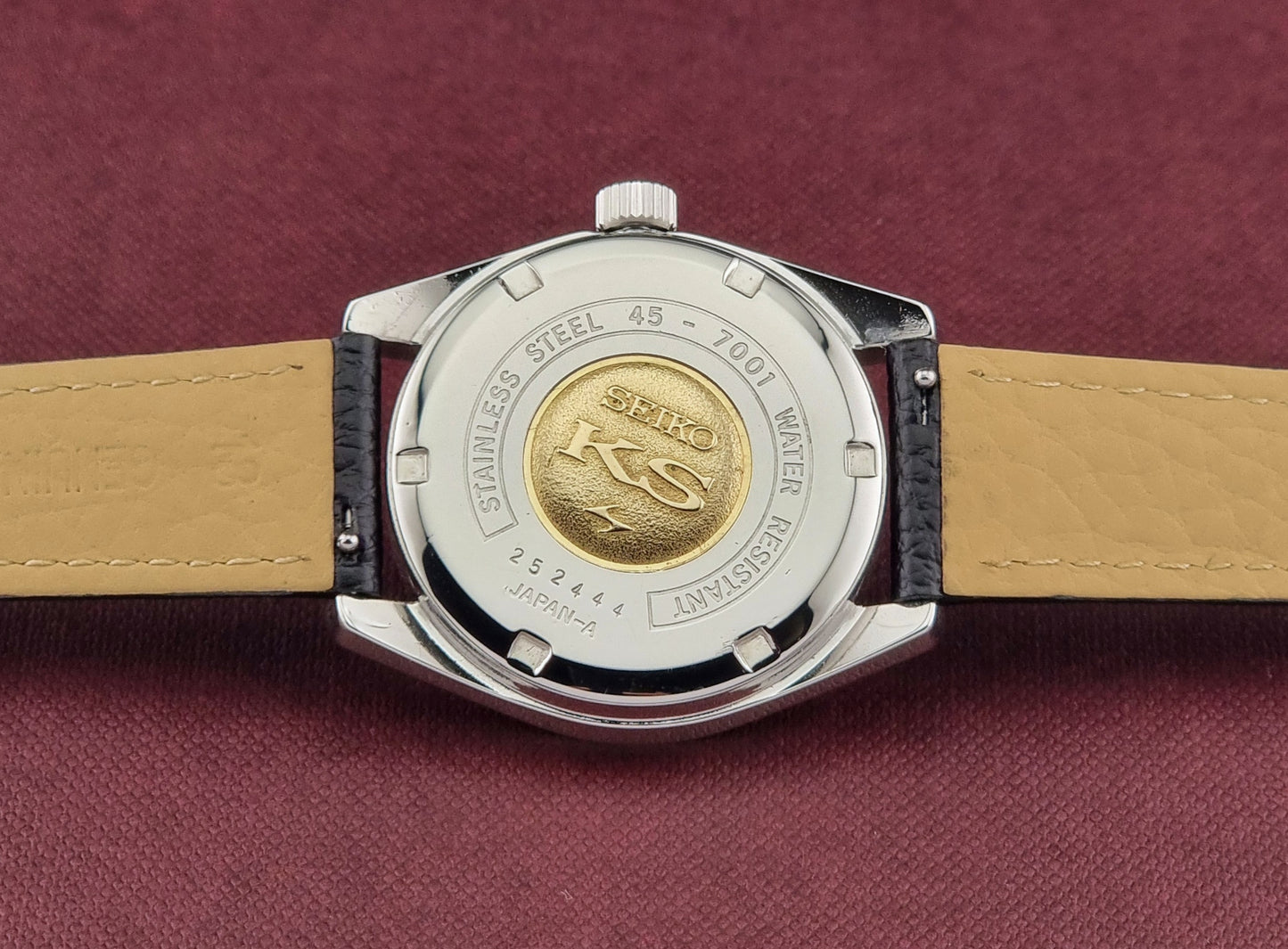King Seiko 45-7001 Watch case back with brand logo on a maroon background
