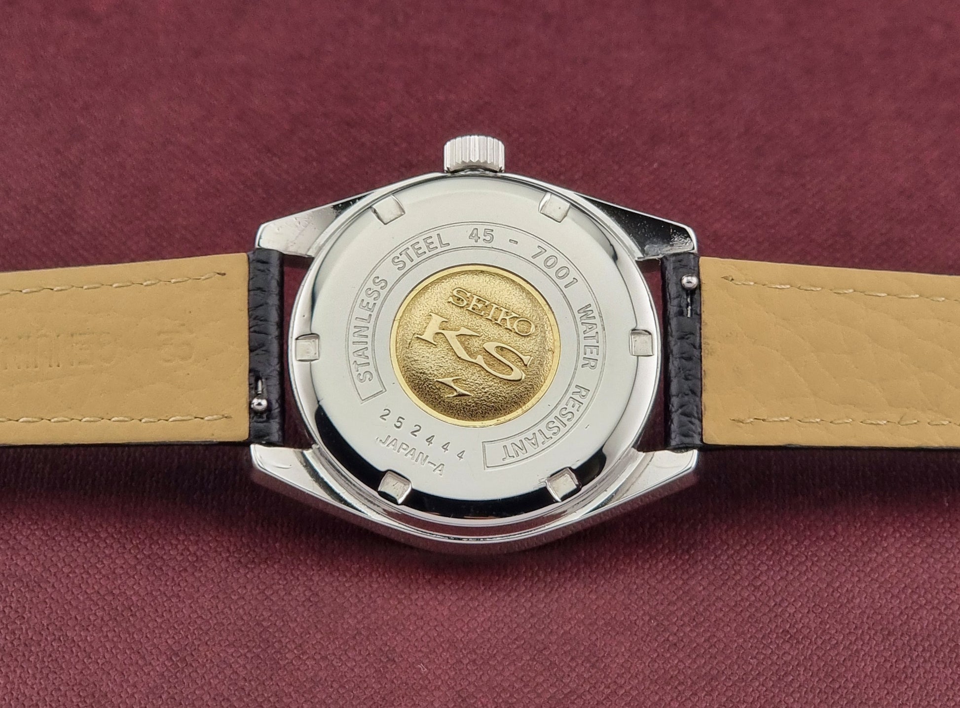 King Seiko 45-7001 Watch case back with brand logo on a maroon background