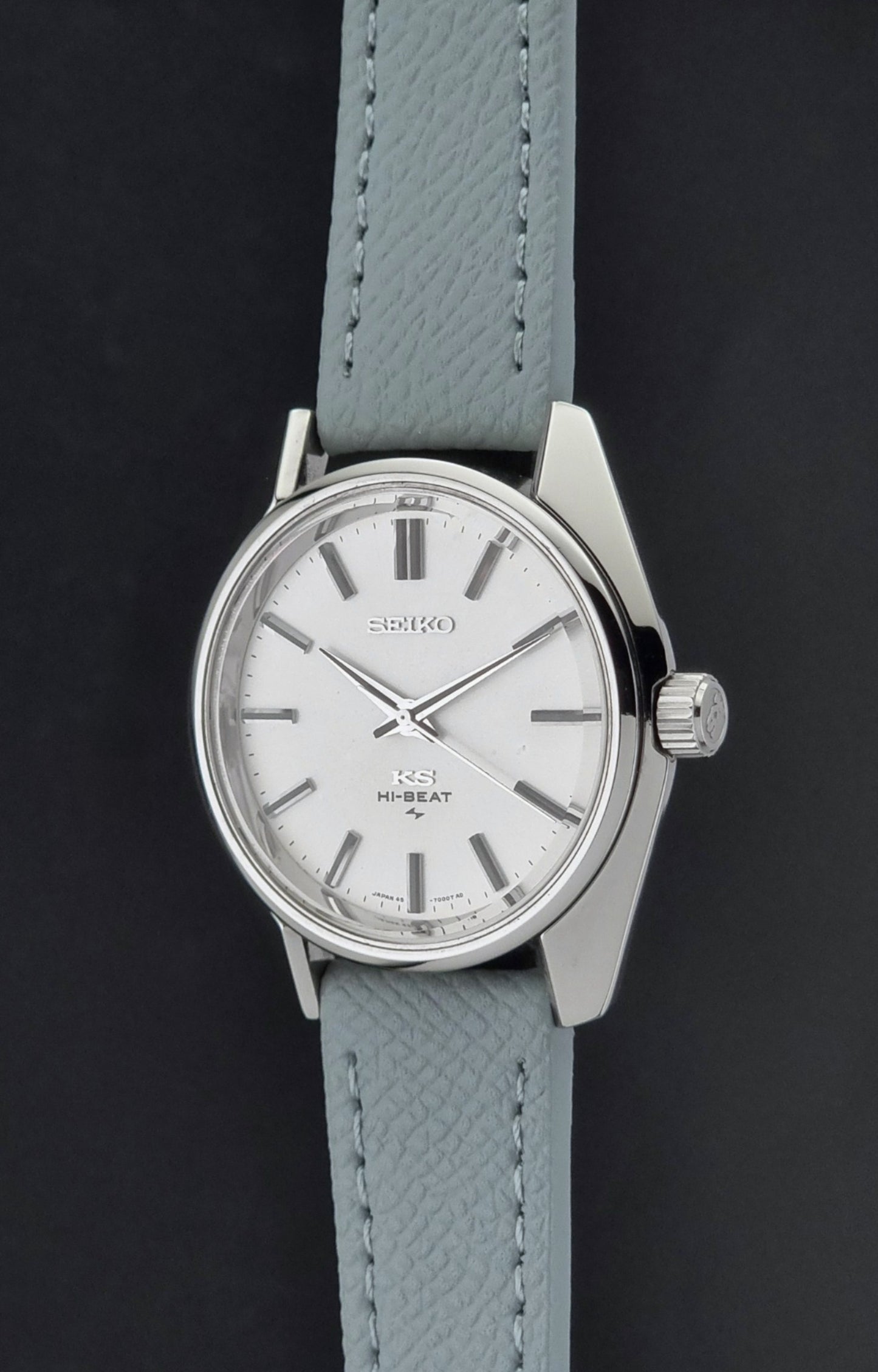 Vintage King Seiko 45-7001 watch with a grey leather strap on a brown background crown profile view