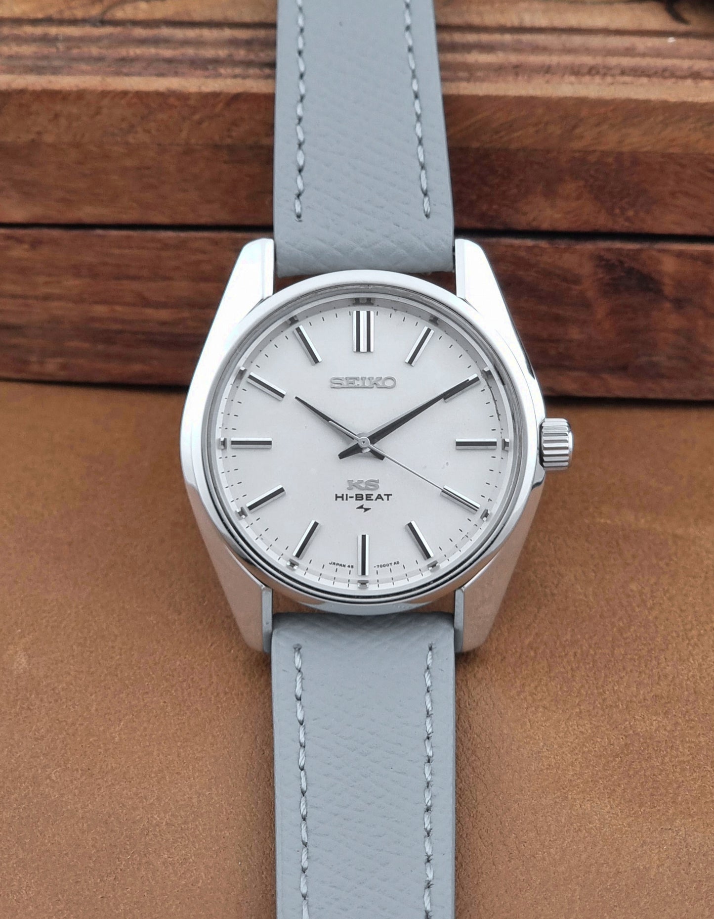 Vintage King Seiko 45-7001 watch with a grey leather strap on a brown background dial view