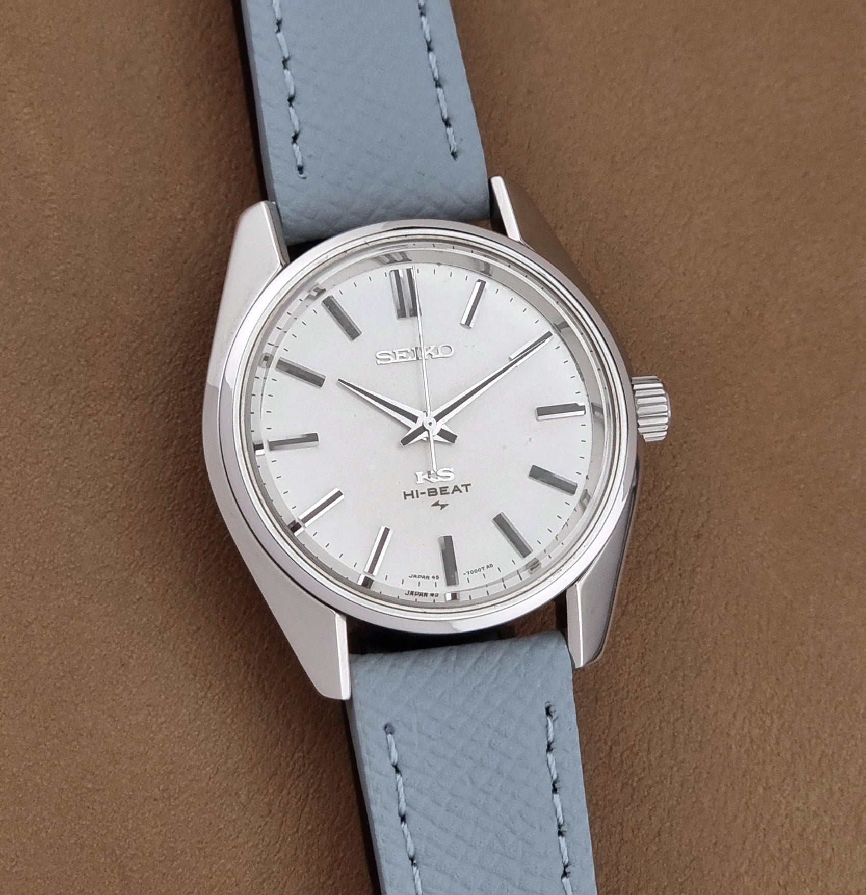Vintage King Seiko 45-7001 watch with a grey leather strap on a brown background front view