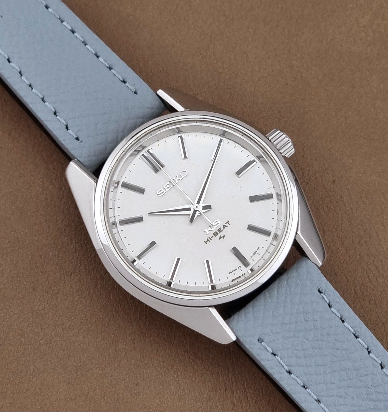 Vintage King Seiko 45-7001 watch with a grey leather strap on a brown background close up dial view
