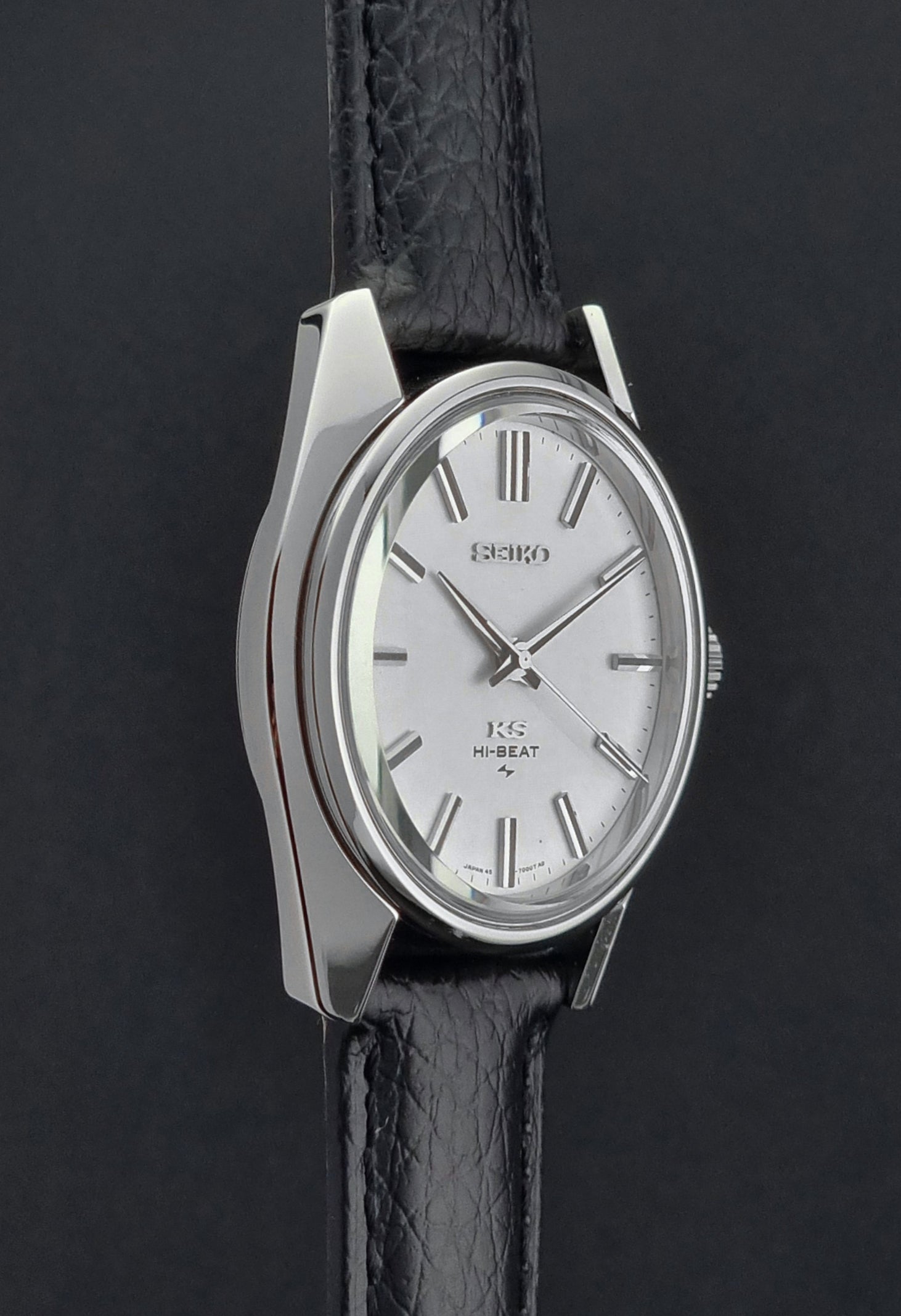 King Seiko 45-7001 watch with silver case and white face on a black strap against a dark background
