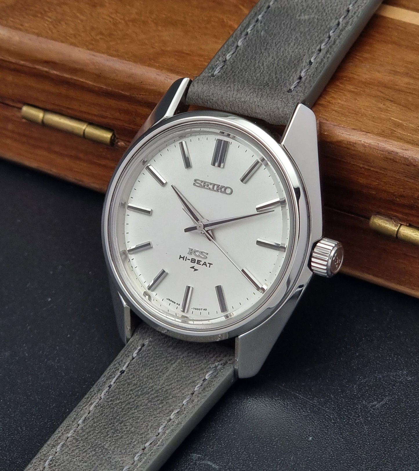 Vintage King Seiko watch with gray strap on a dark surface