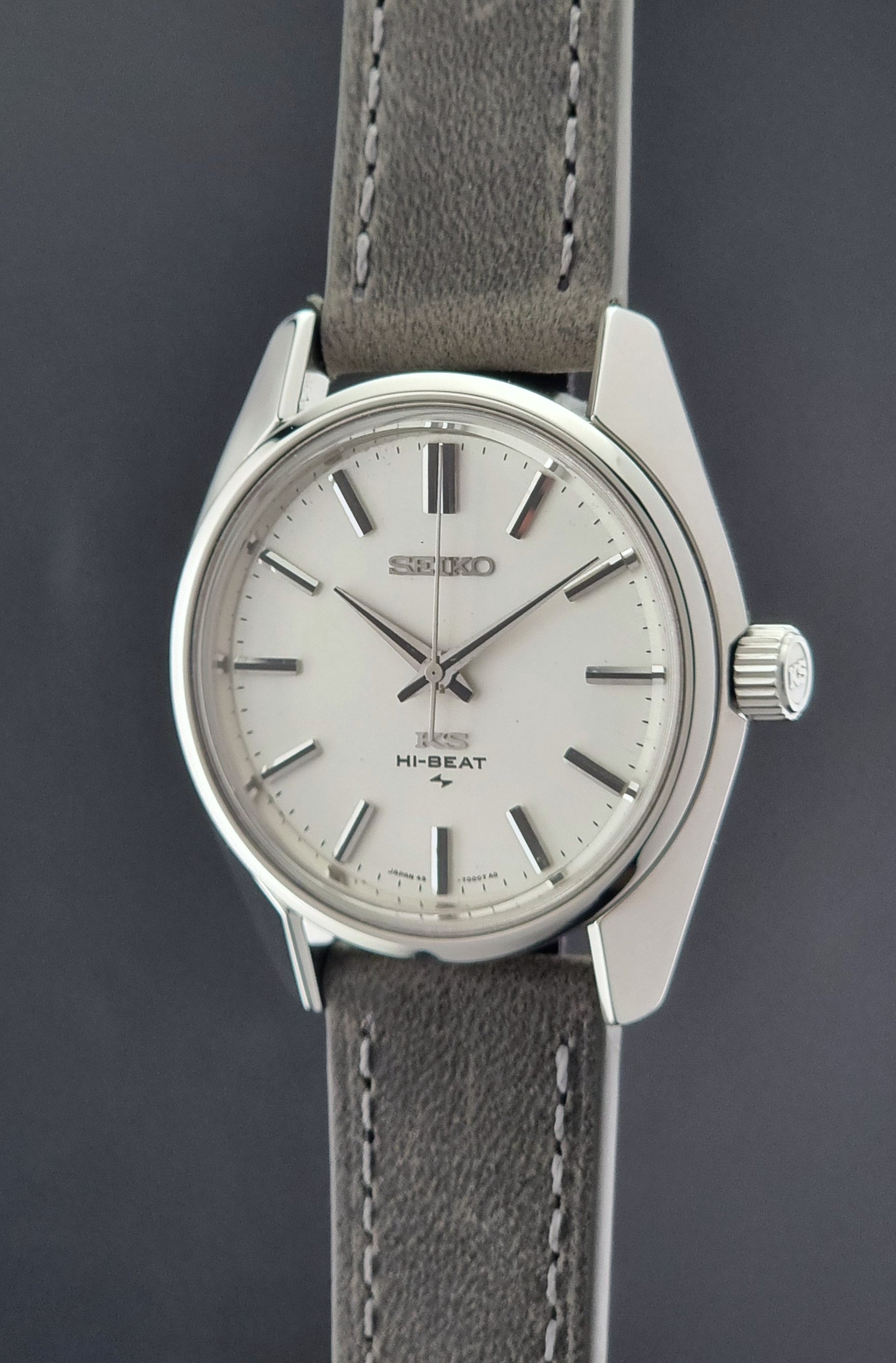 Vintage King Seiko watch with silver case and gray leather strap on a dark background
