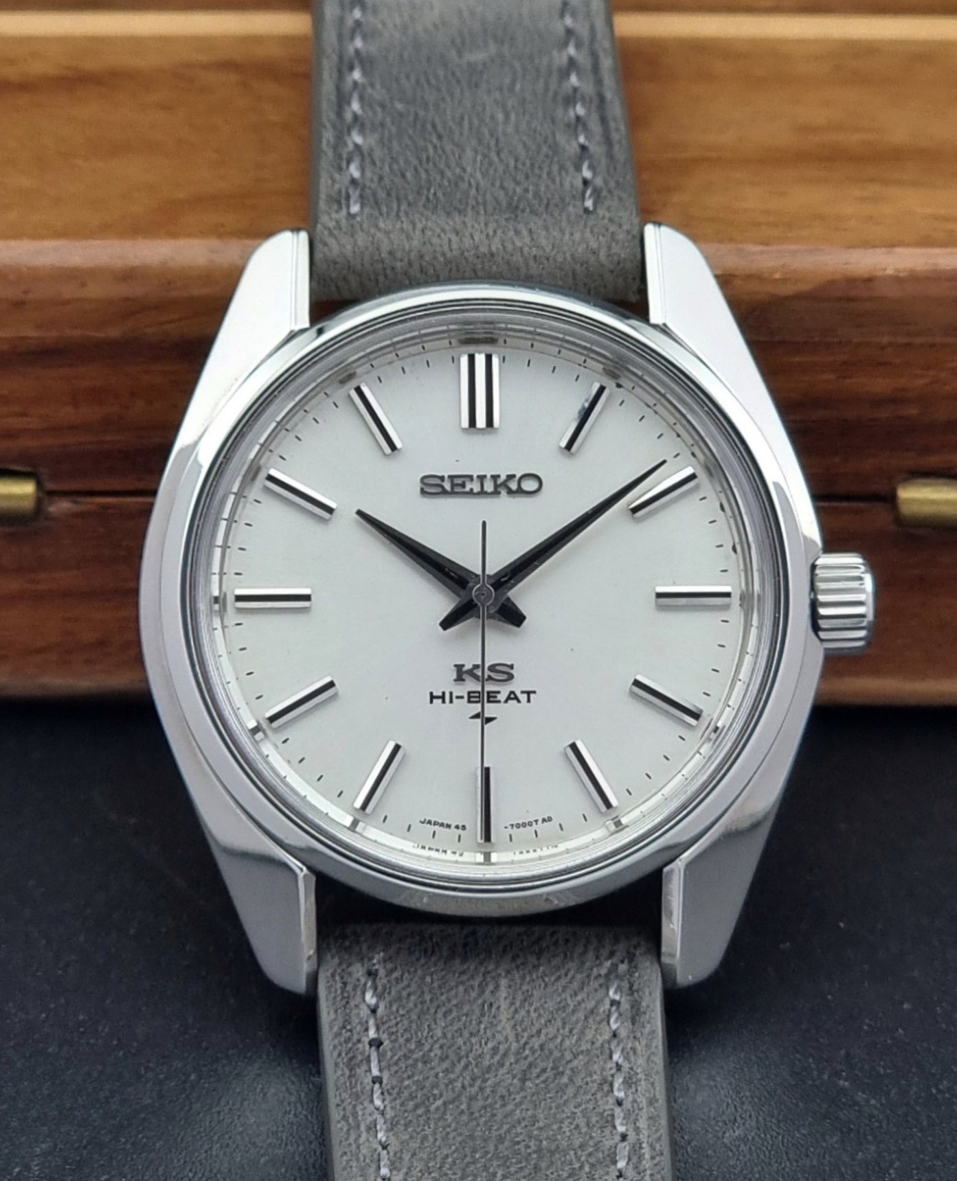 Vintage King Seiko watch with gray strap on a wooden surface