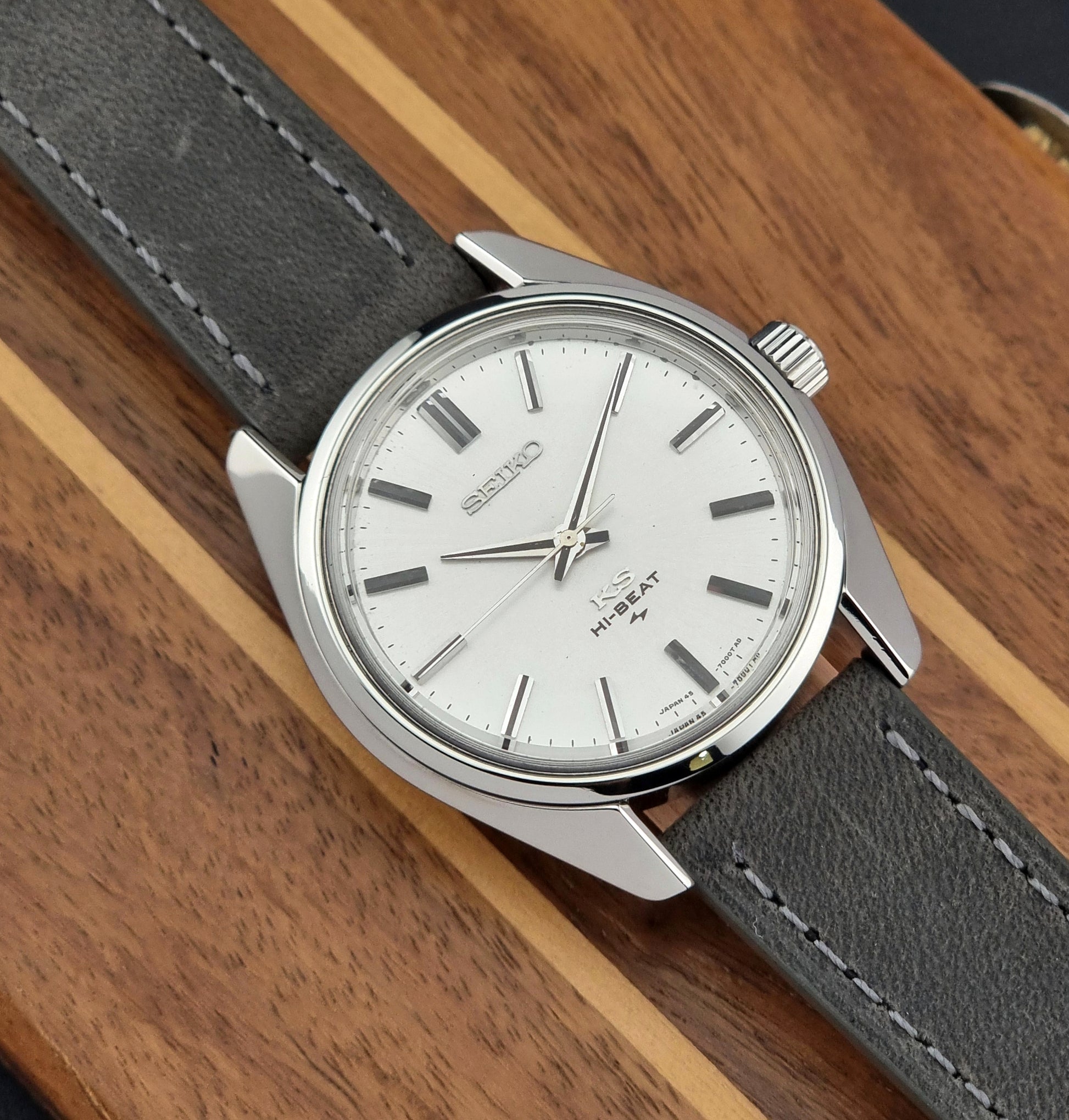 Vintage King Seiko watch with gray strap and silver case on wooden surface