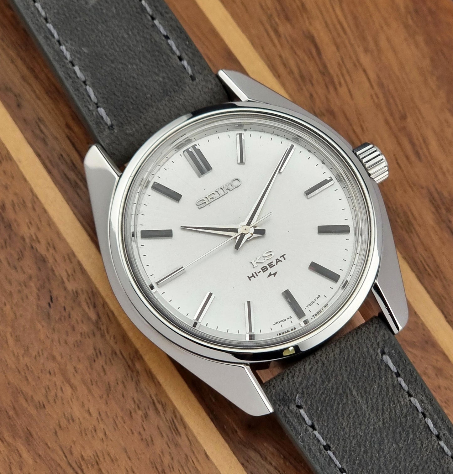 Vintage King Seiko watch with gray strap on a wooden surface