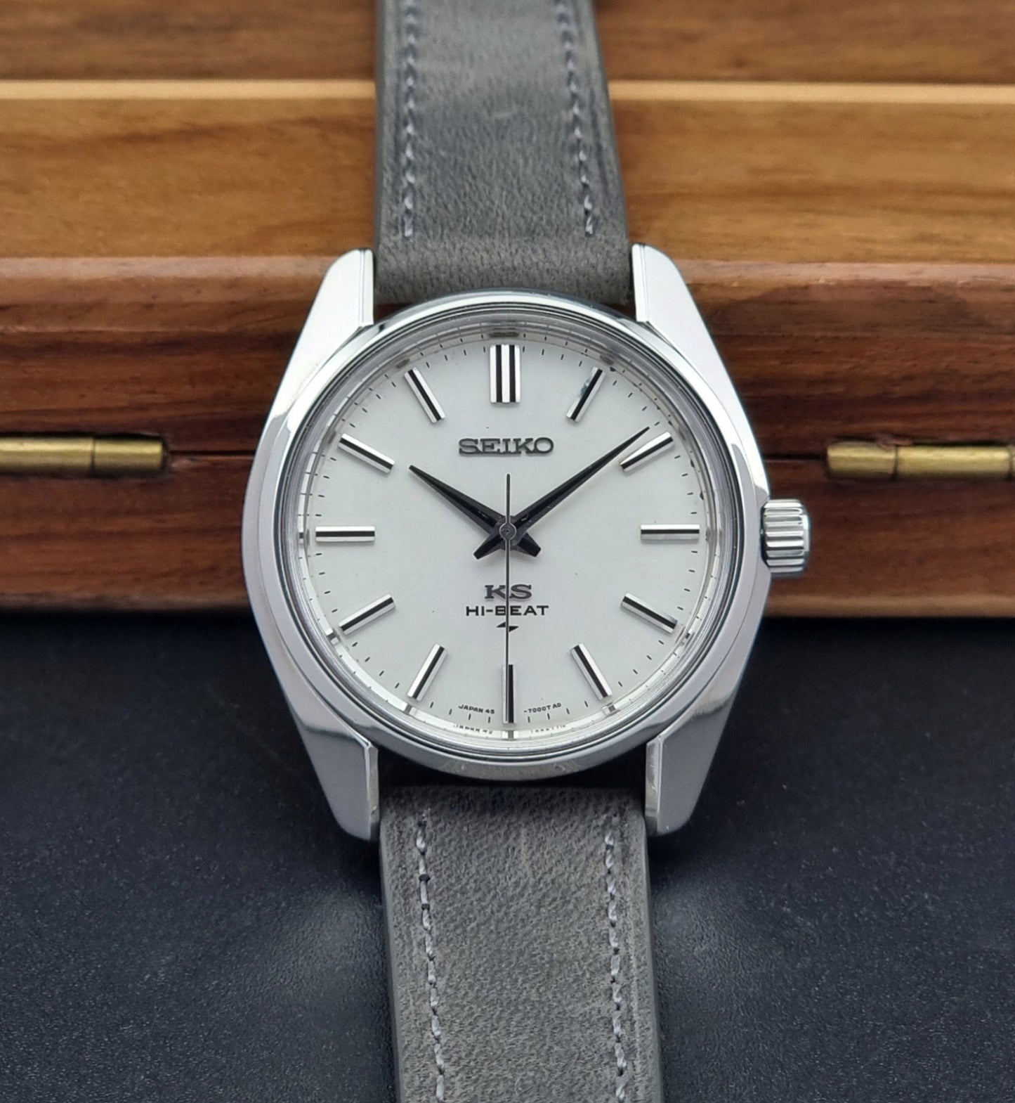 Vintage King Seiko watch with gray strap on a wooden surface