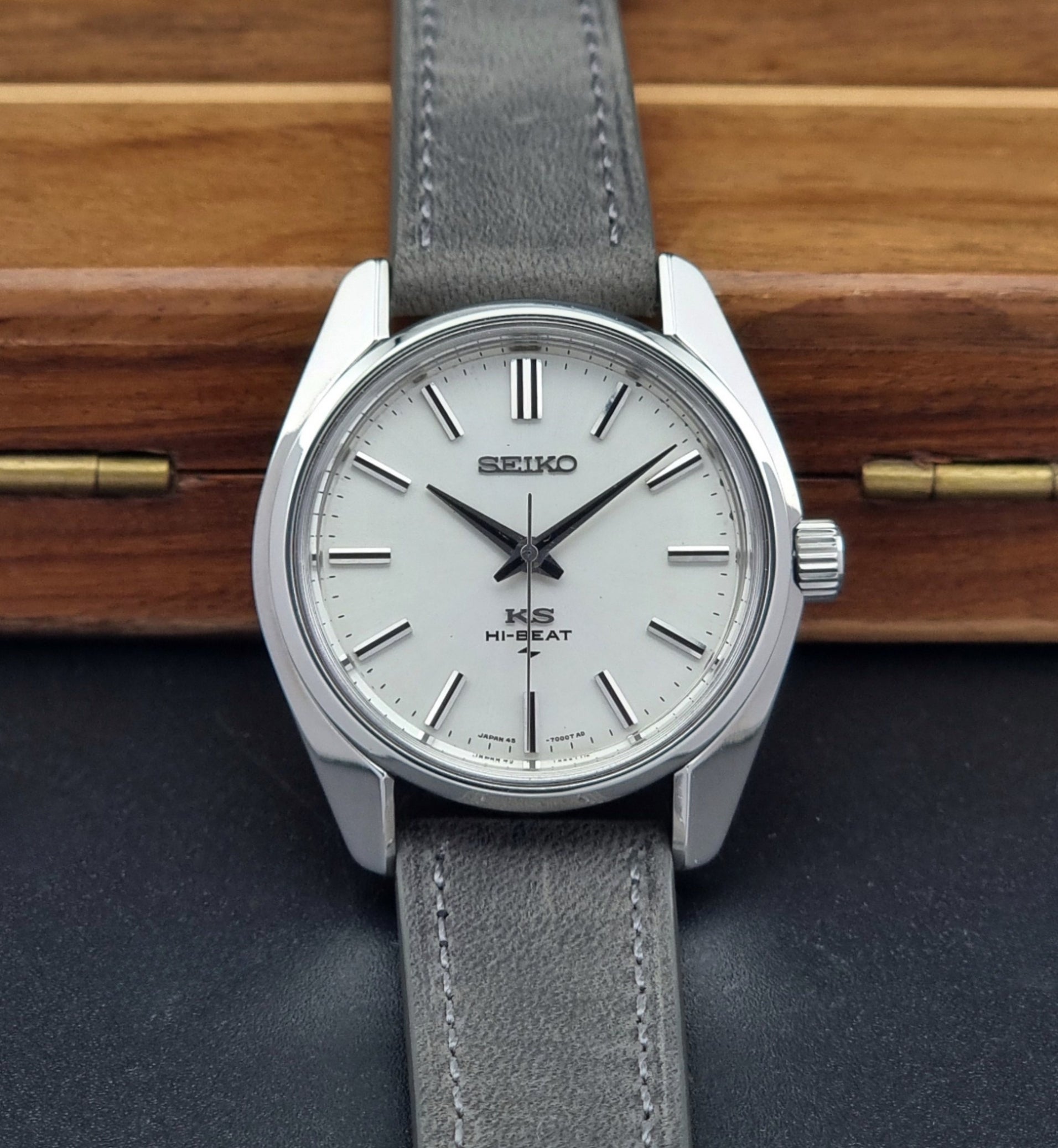 Vintage King Seiko watch with gray strap on a wooden surface