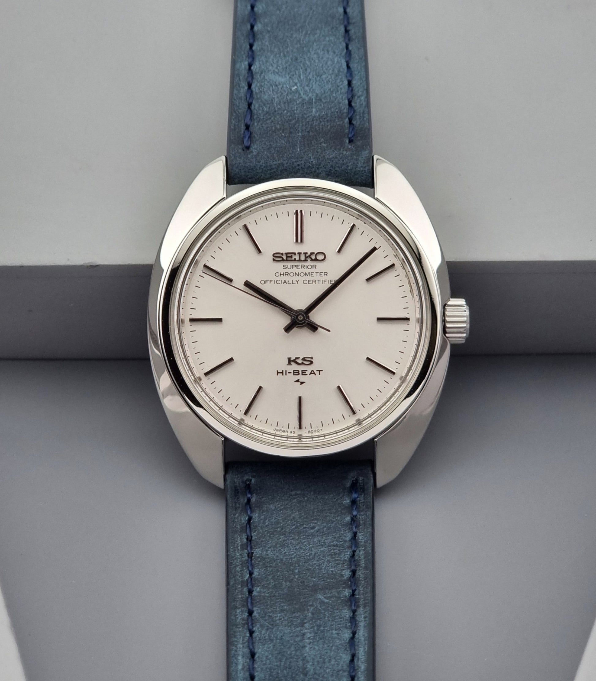 Vintage King Seiko Wristwatch with blue leather strap on a gray background
