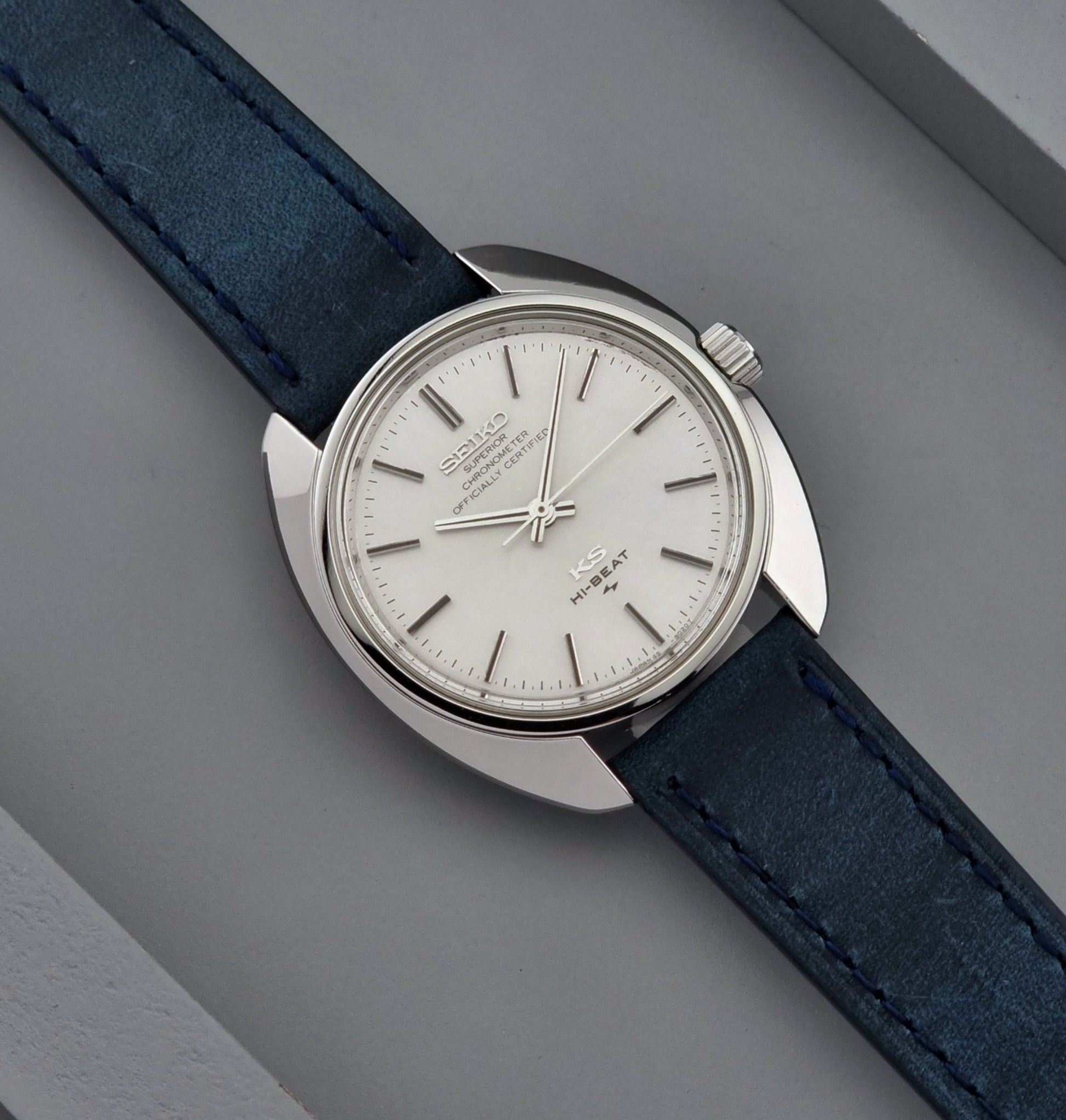 Vintage King Seiko Wristwatch with blue strap and silver case on a gray background