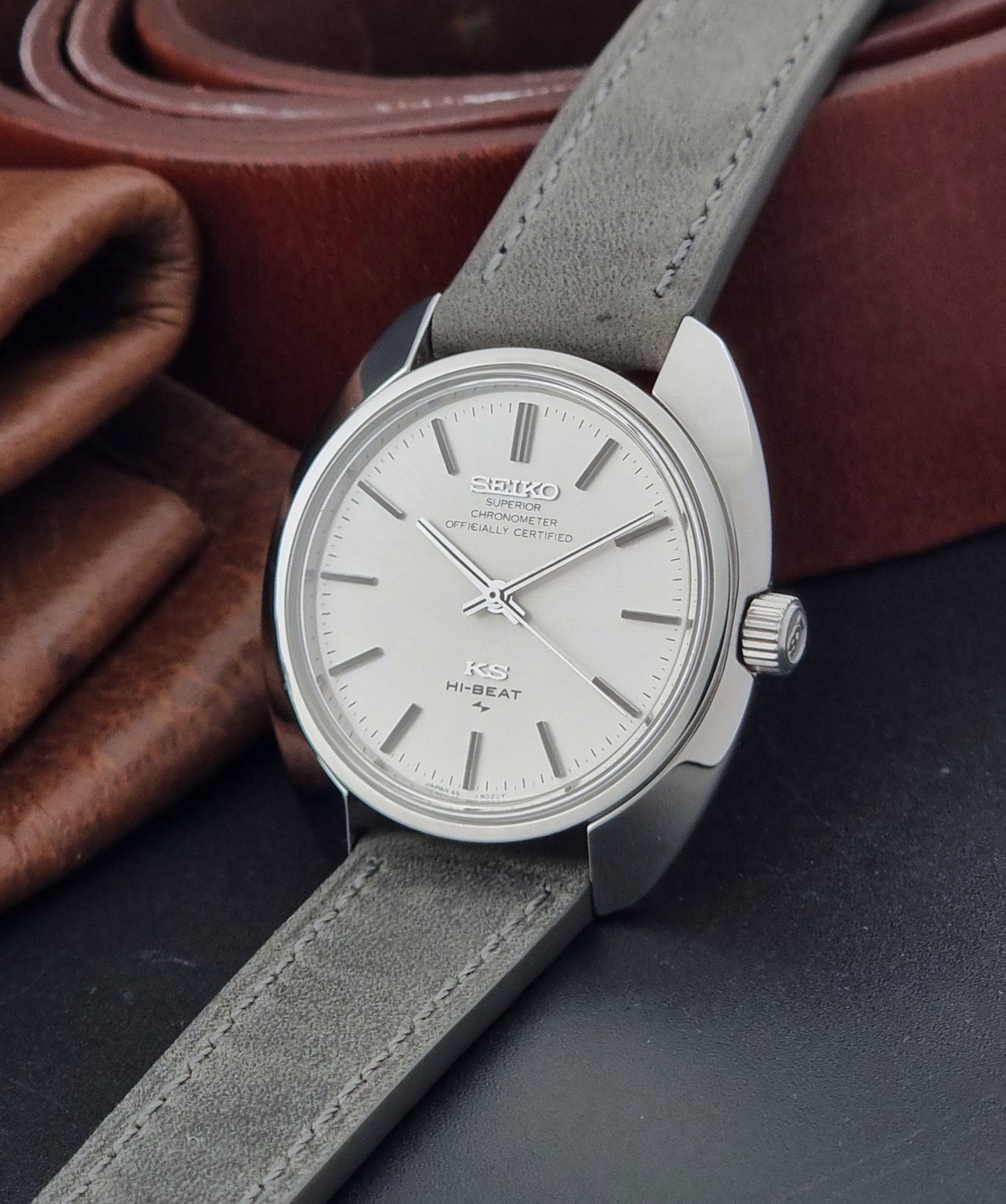 Vintage King Seiko 45-8010 Wristwatch with gray strap and silver case on a dark surface crown view