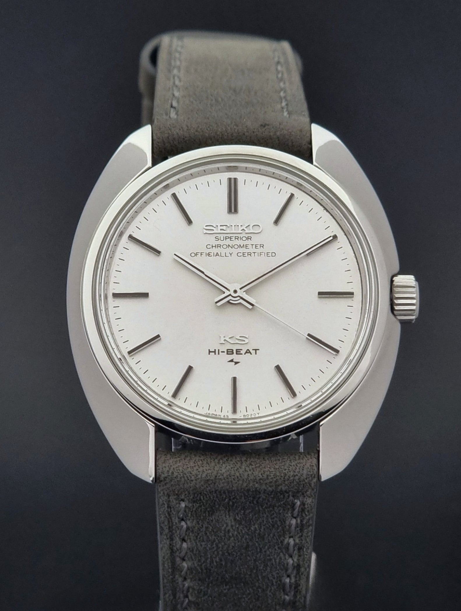 Vintage King Seiko 45-8010 Wristwatch with gray strap and silver case on a dark surface close up front