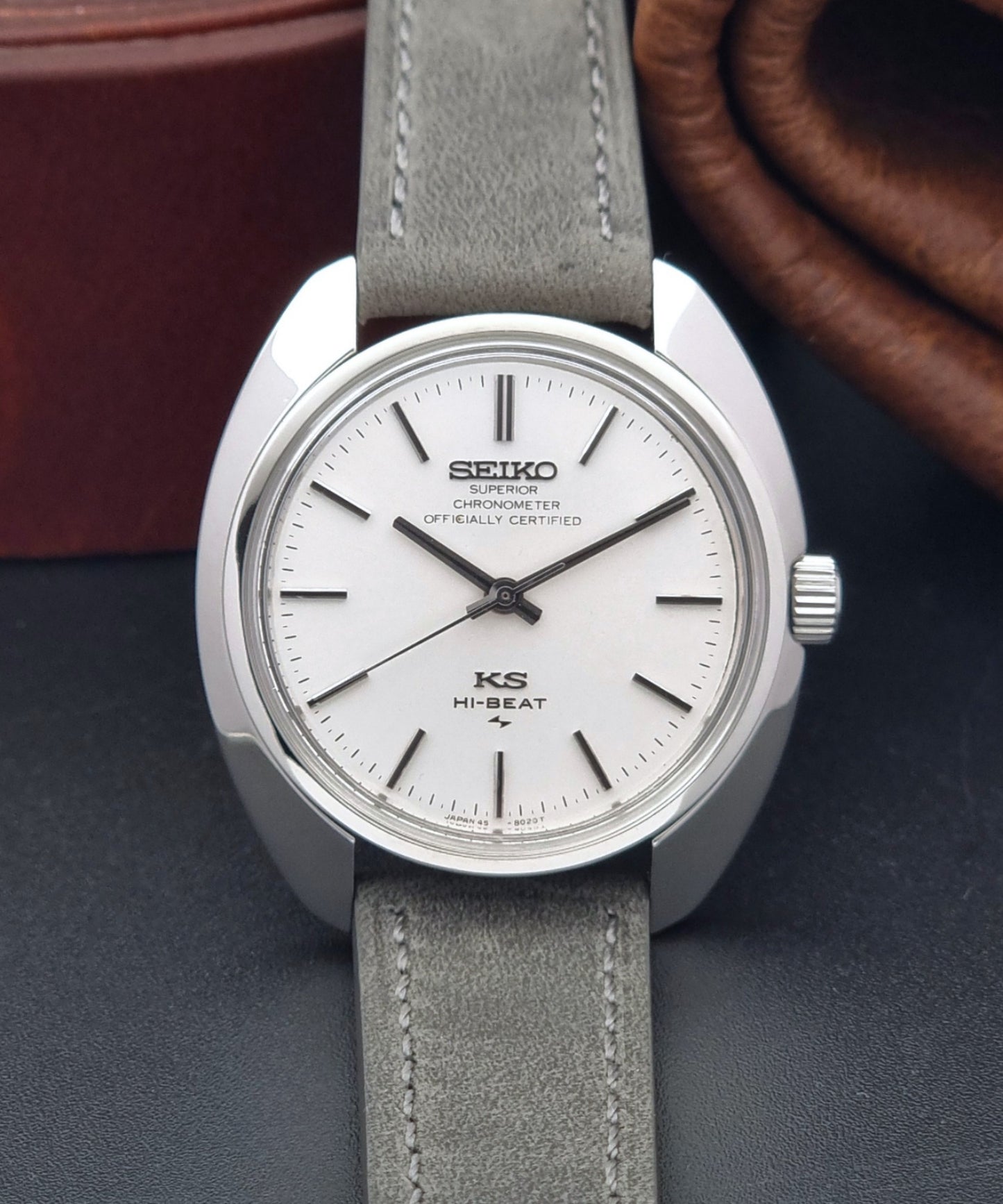 Vintage King Seiko 45-8010 Wristwatch with gray strap and silver case on a dark surface front view