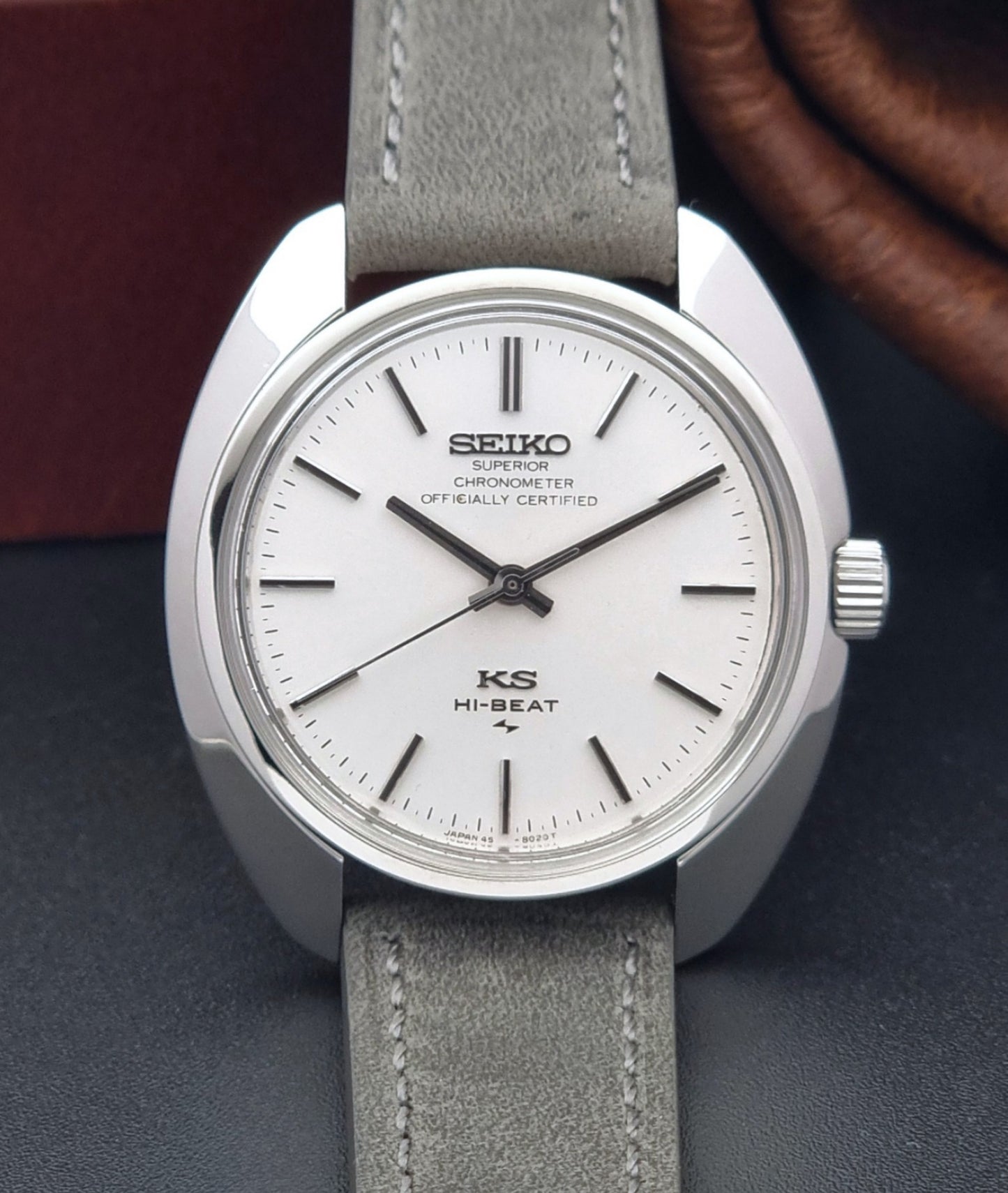 Vintage King Seiko 45-8010 Wristwatch with gray strap and silver case on a dark surface close up dial view