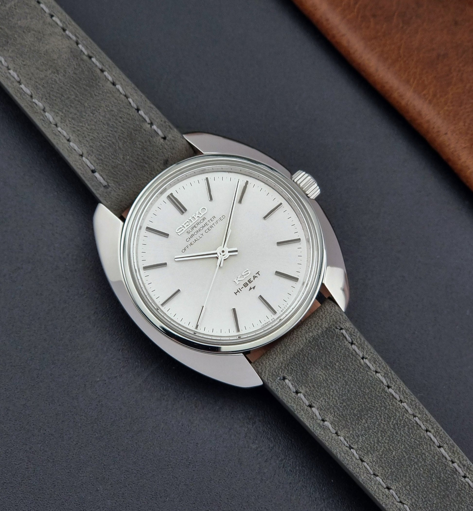 Vintage King Seiko 45-8010 Wristwatch with gray strap and silver case on a dark surface front
