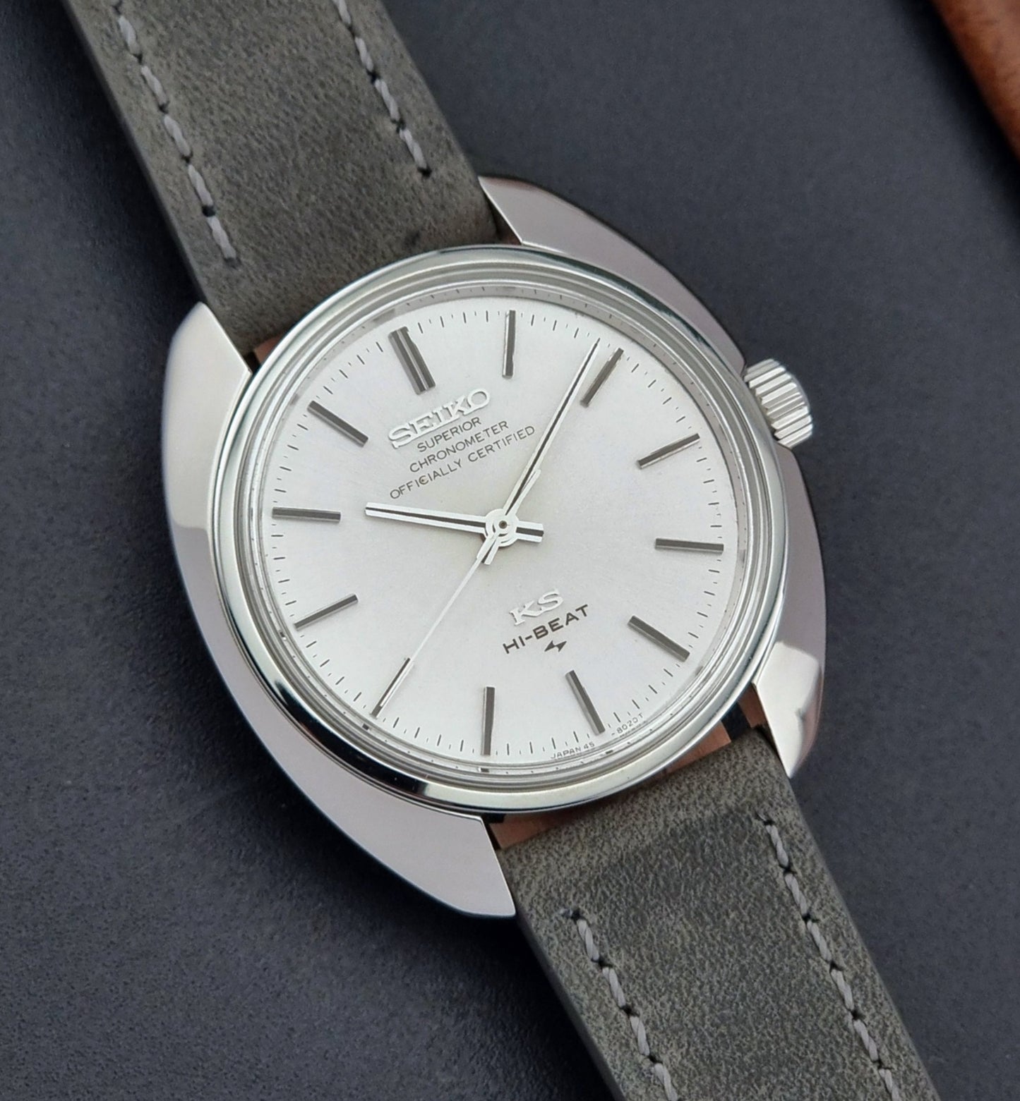 Vintage King Seiko 45-8010 Wristwatch with gray strap and silver case on a dark surface dial view