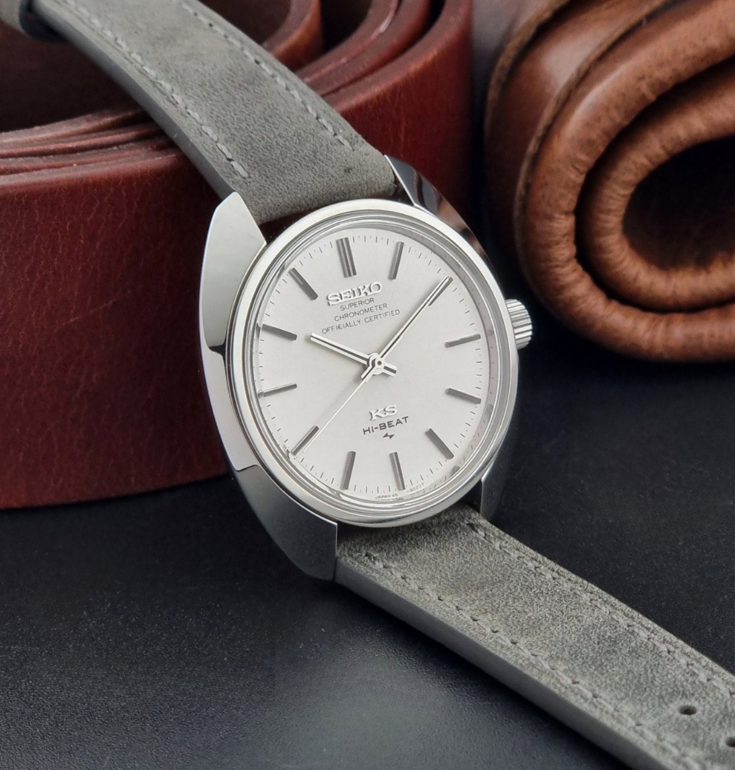 Vintage King Seiko 45-8010 Wristwatch with gray strap and silver case on a dark surface side view