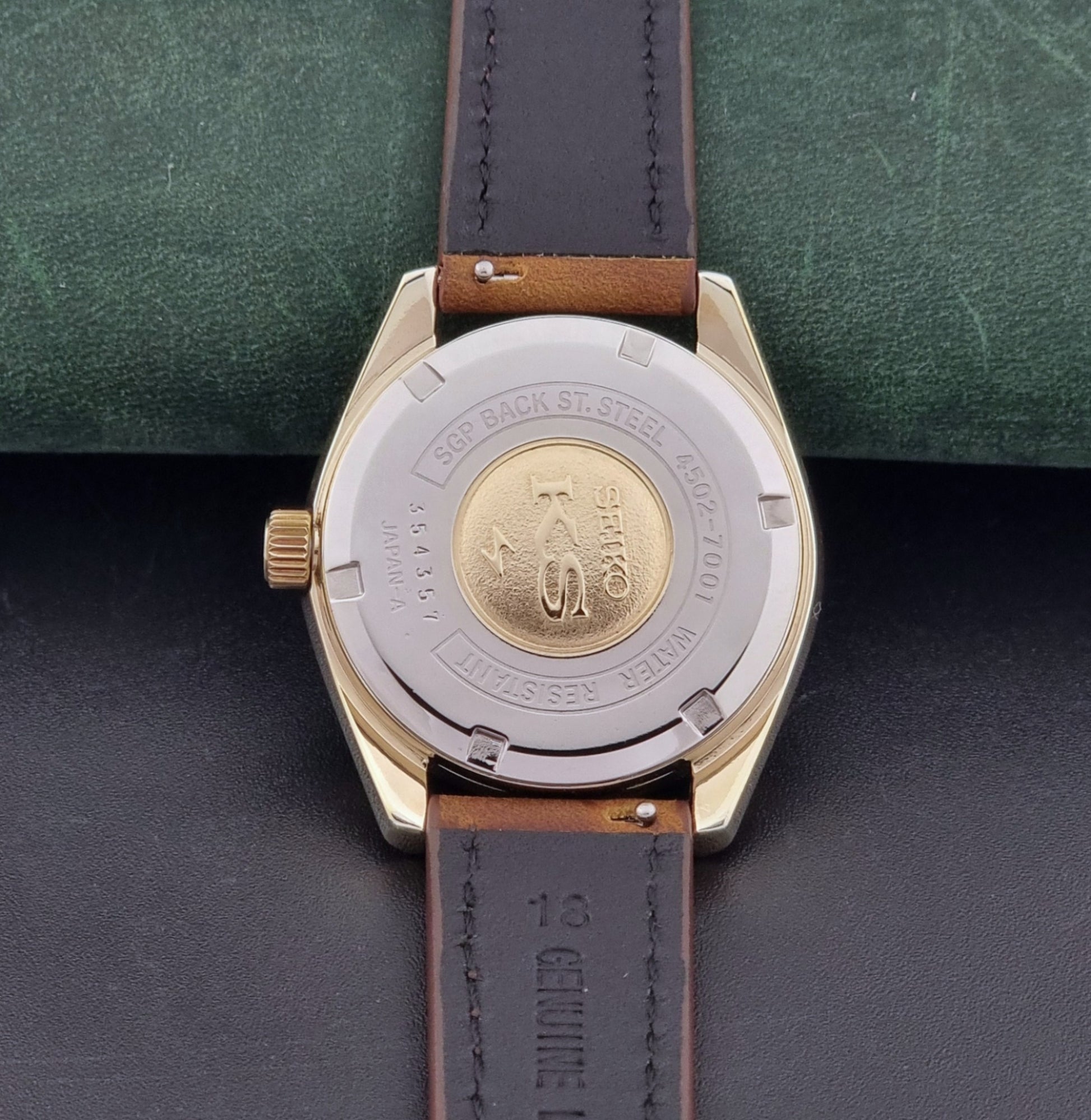 Vintage King Seiko 4502-7001 Wristwatch with brown leather strap on a dark surface case back view