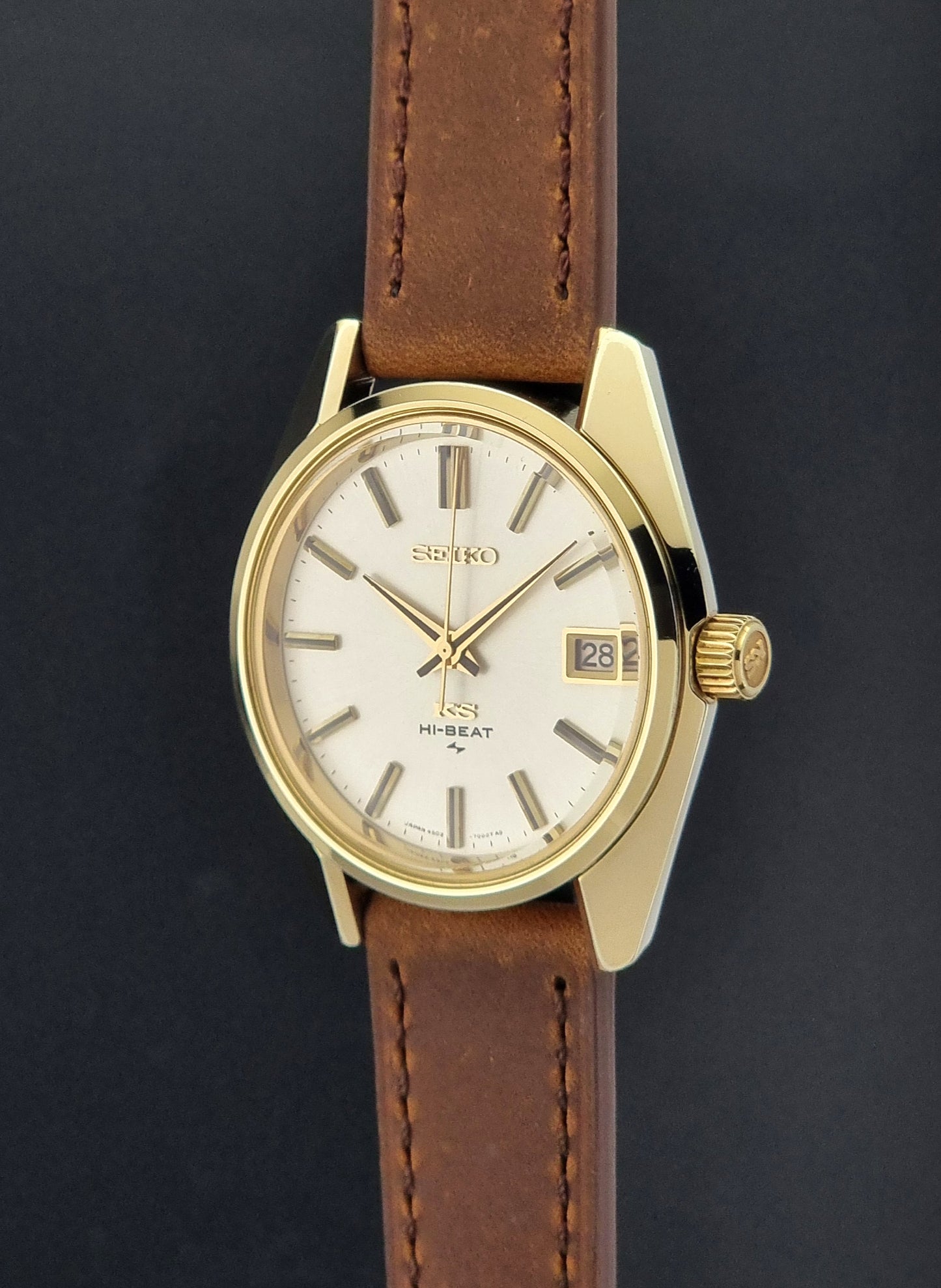 Vintage King Seiko 4502-7001 Wristwatch with brown leather strap on a dark surface crown profile view