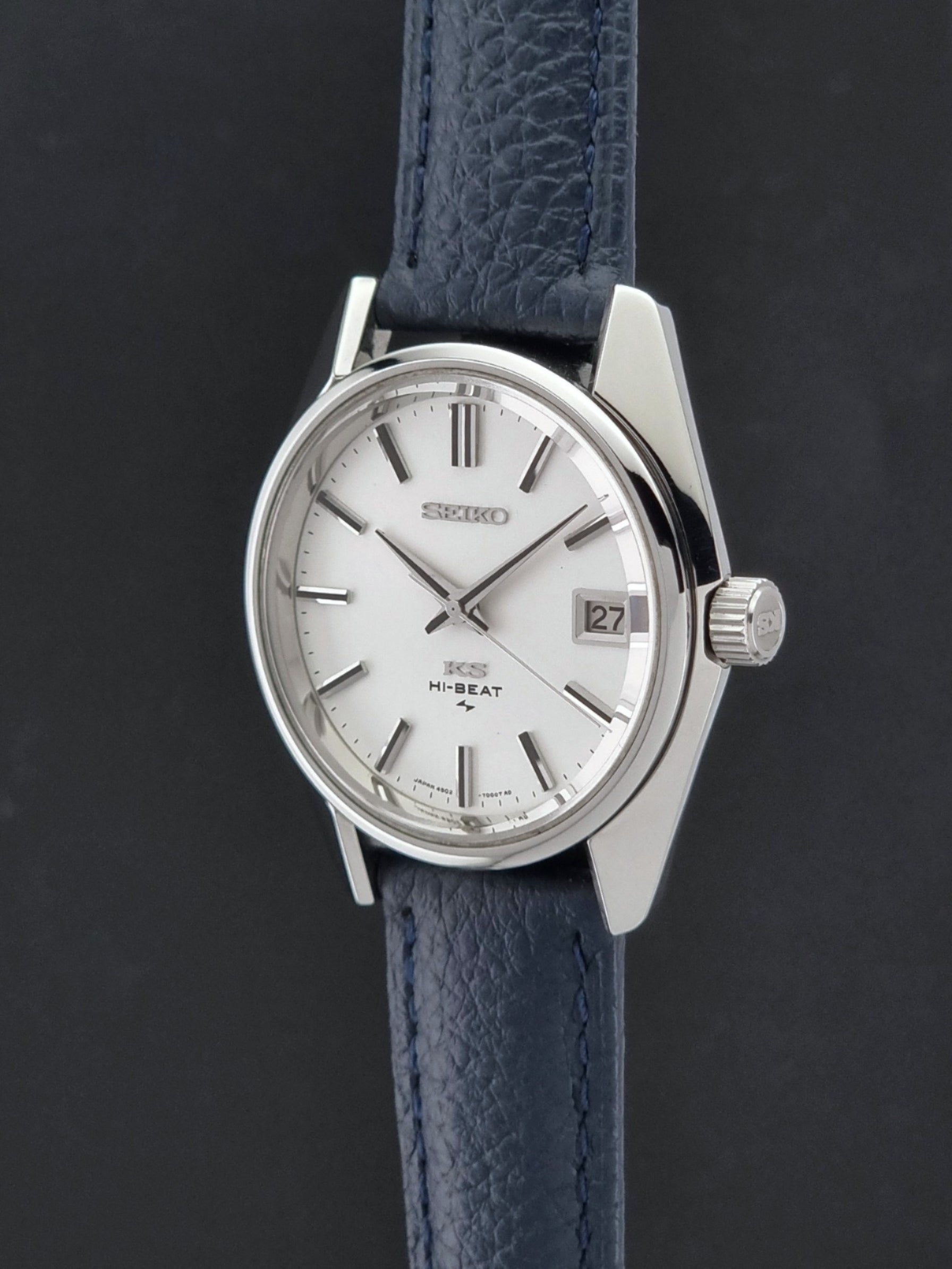 Vintage King Seiko 4502-7001 watch with a blue leather strap on a grey back ground crown profile view