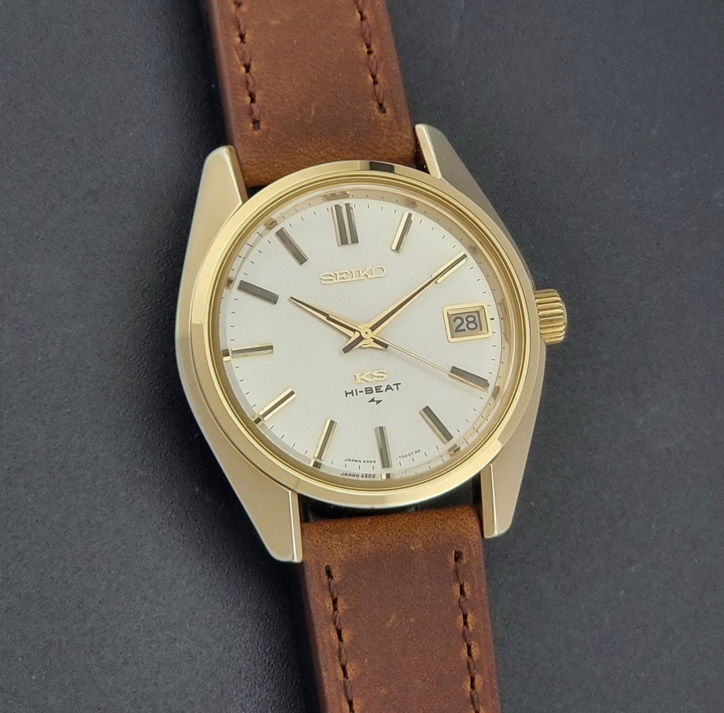 Vintage King Seiko 4502-7001 Wristwatch with brown leather strap on a dark surface front view