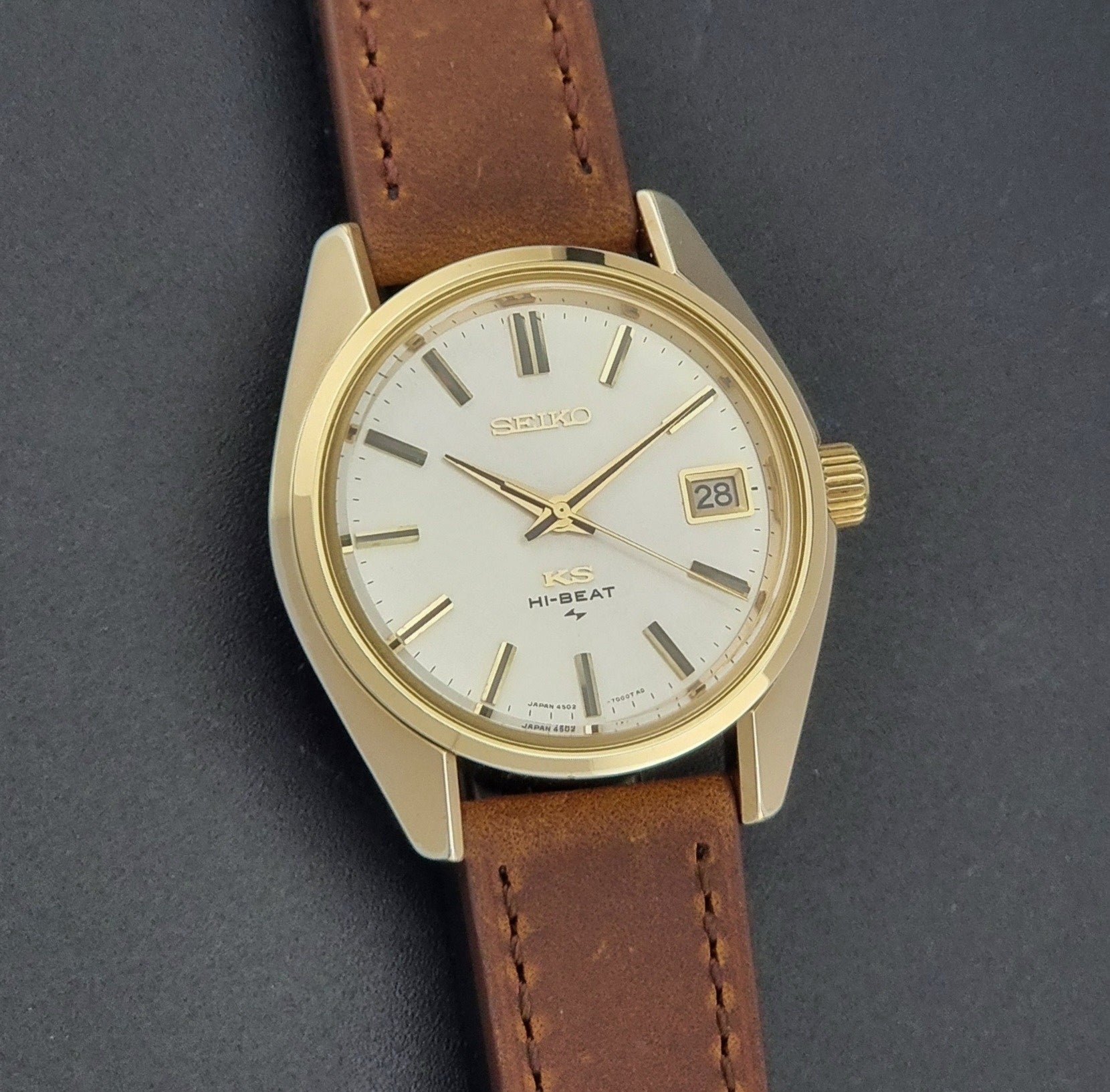Vintage King Seiko 4502-7001 Wristwatch with brown leather strap on a dark surface front view