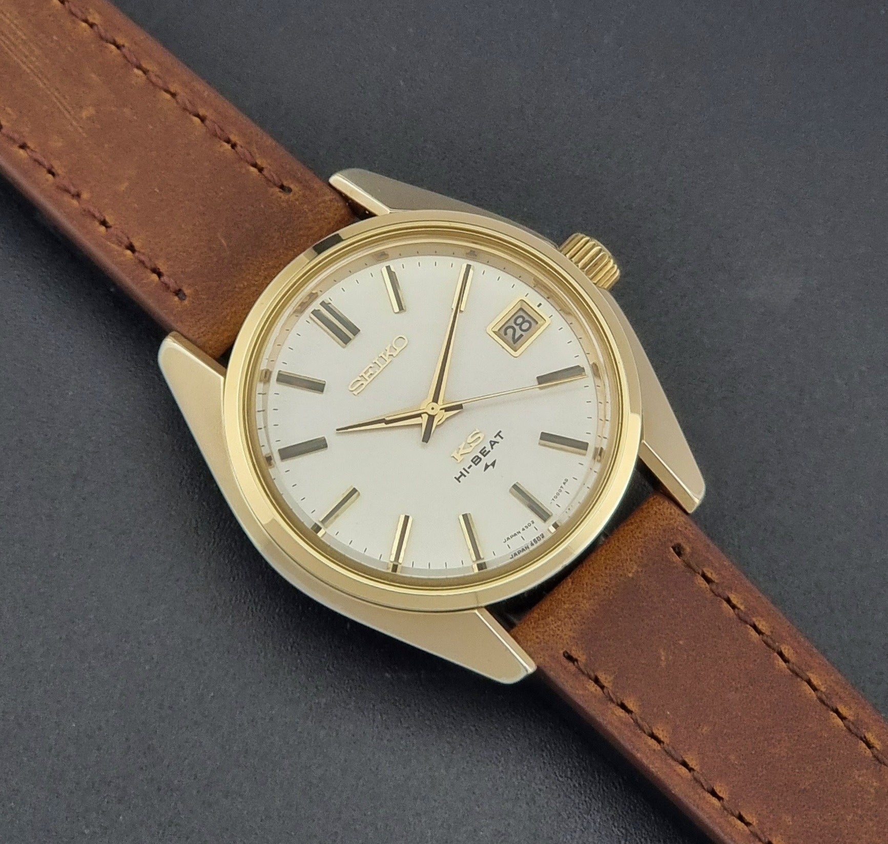 Vintage King Seiko 4502-7001 Wristwatch with brown leather strap on a dark surface close up dial view