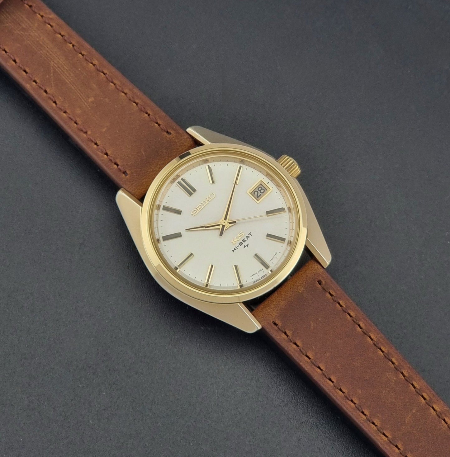 Vintage King Seiko 4502-7001 Wristwatch with brown leather strap on a dark surface dial