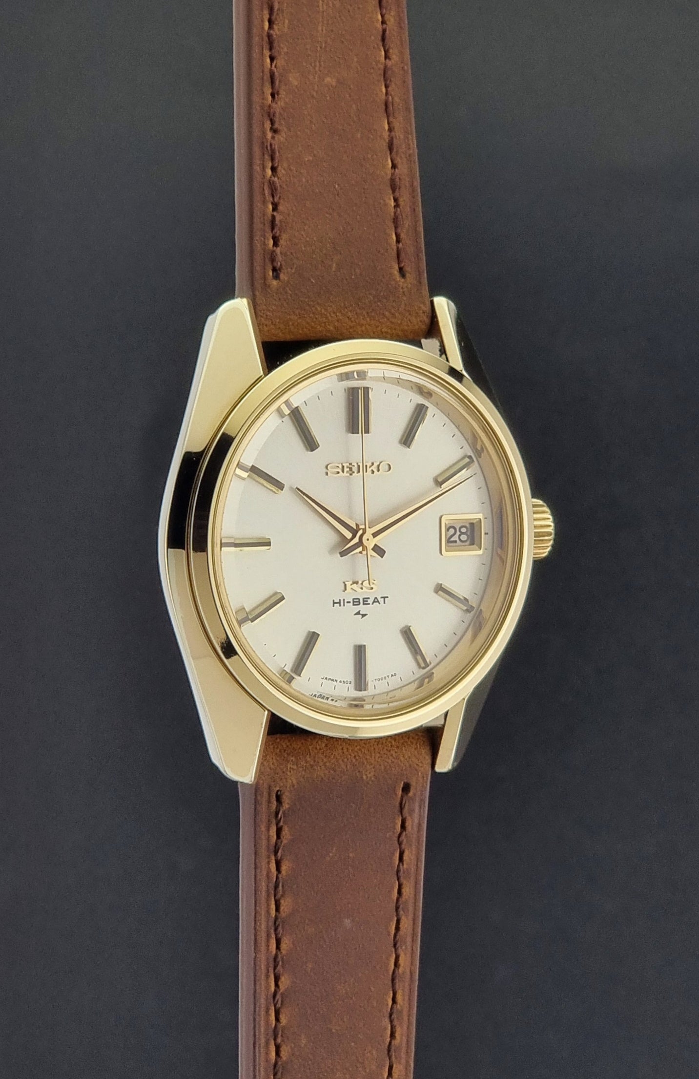 Vintage King Seiko 4502-7001 Wristwatch with brown leather strap on a dark surface side profile view