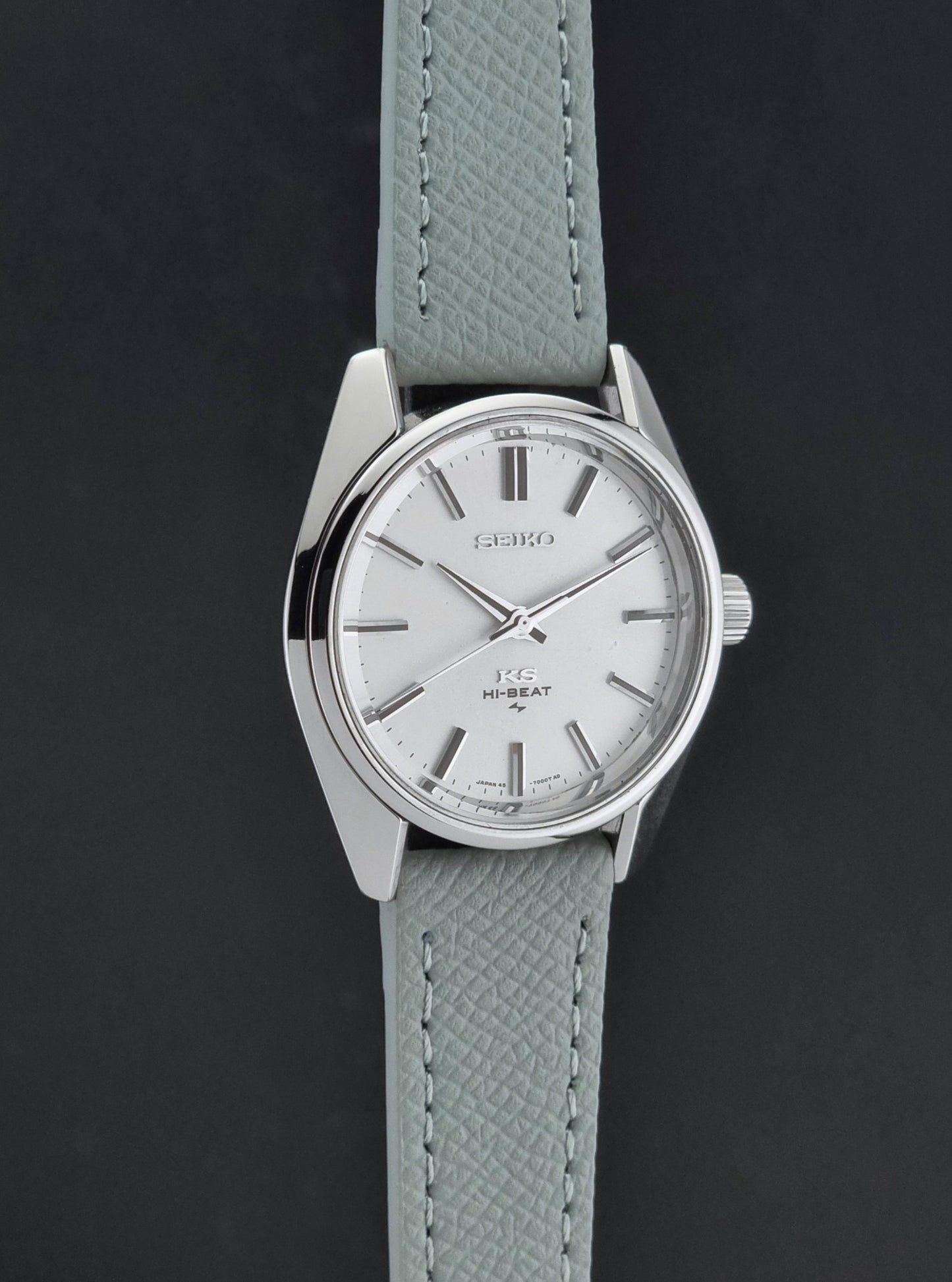 Vintage King Seiko 45-7001 watch with a grey leather strap on a brown background side profile view