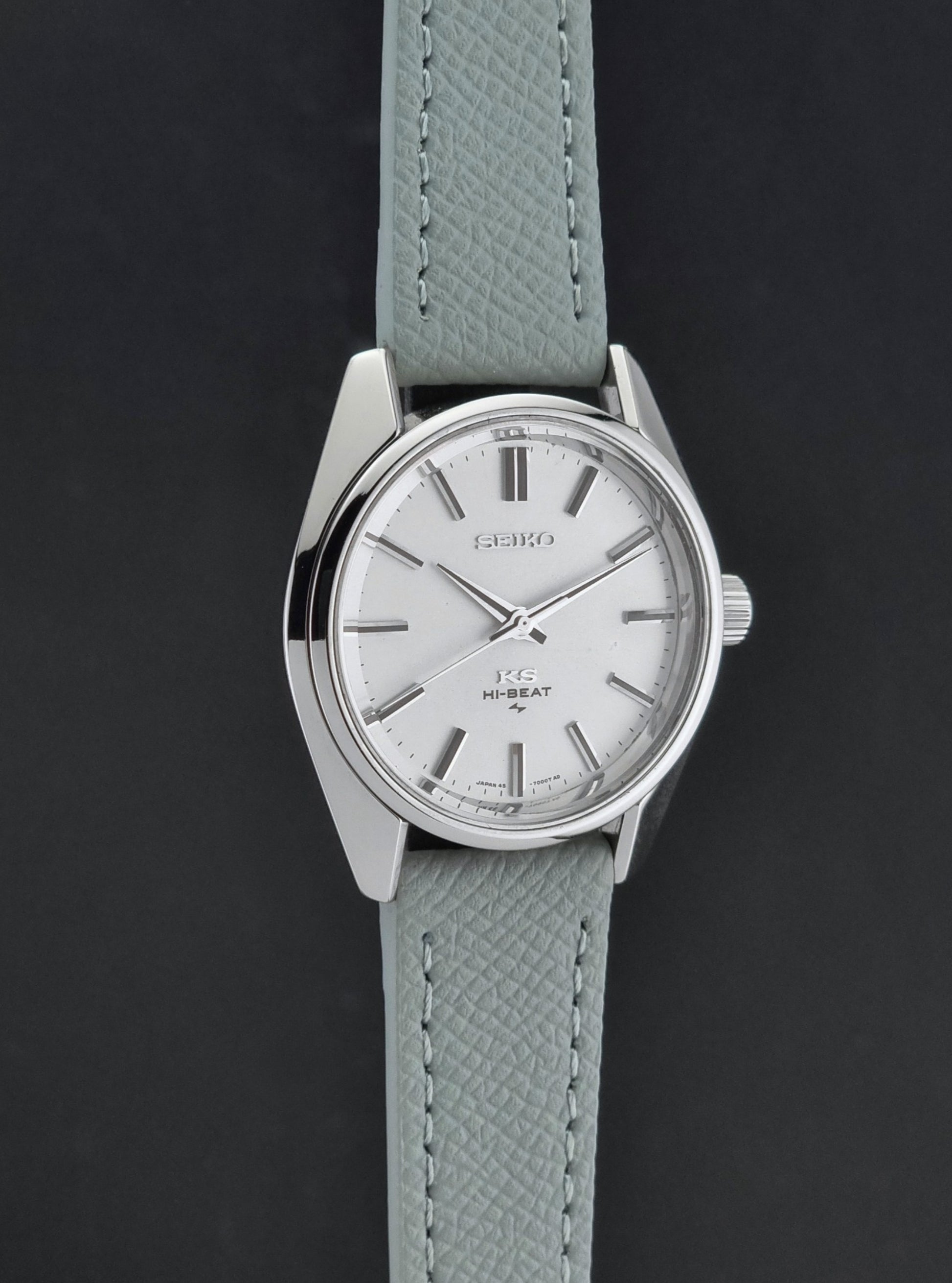 Vintage King Seiko 45-7001 watch with a grey leather strap on a brown background side profile view