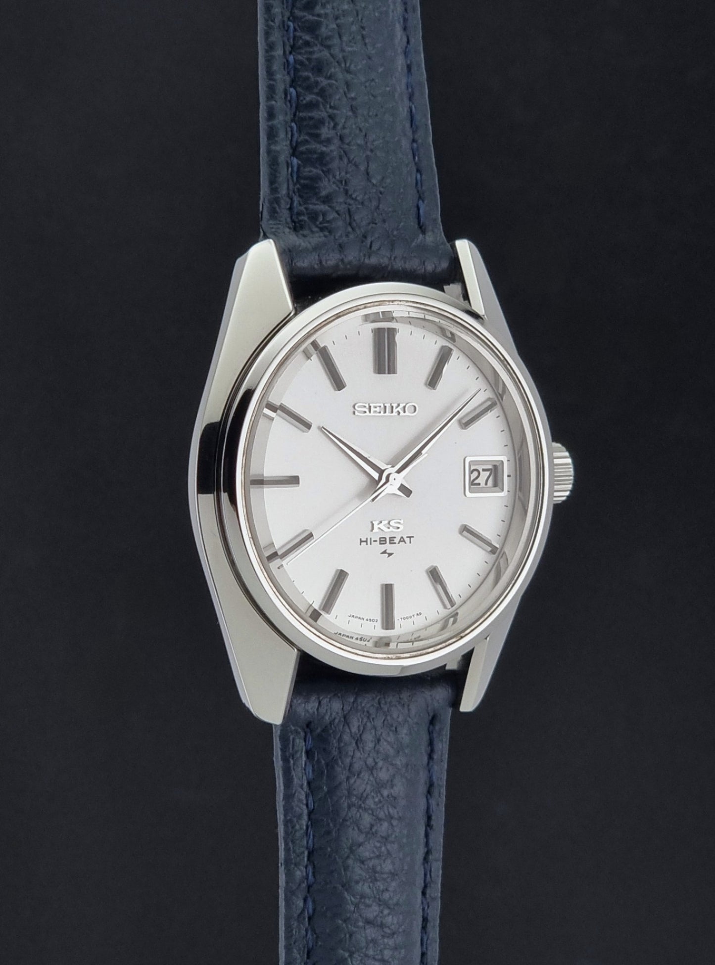 Vintage King Seiko 4502-7001 watch with a blue leather strap on a grey back ground side profile view