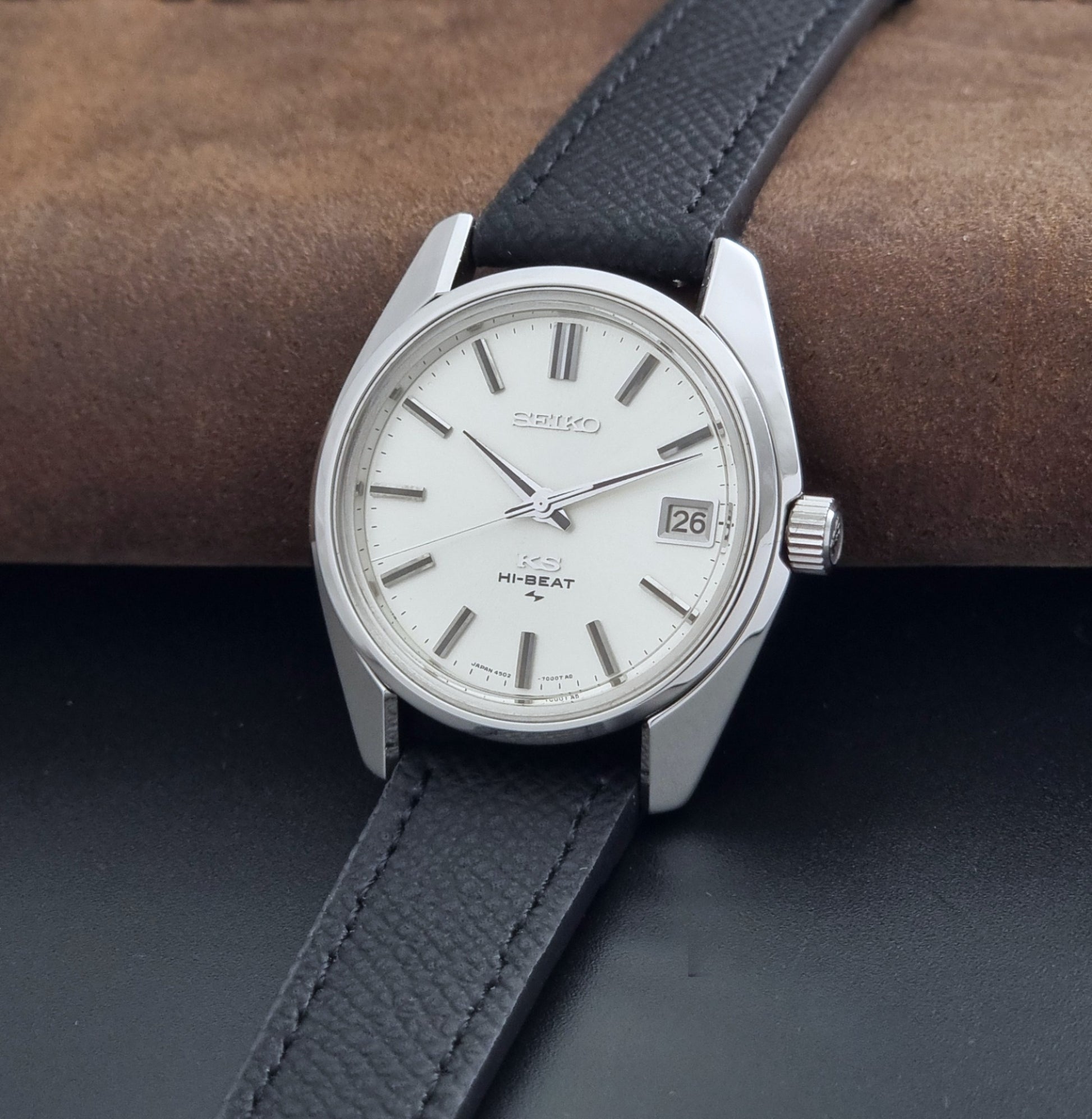 Vintage King Seiko 4502-7001 watch with black strap and silver case on a dark gray background crown view