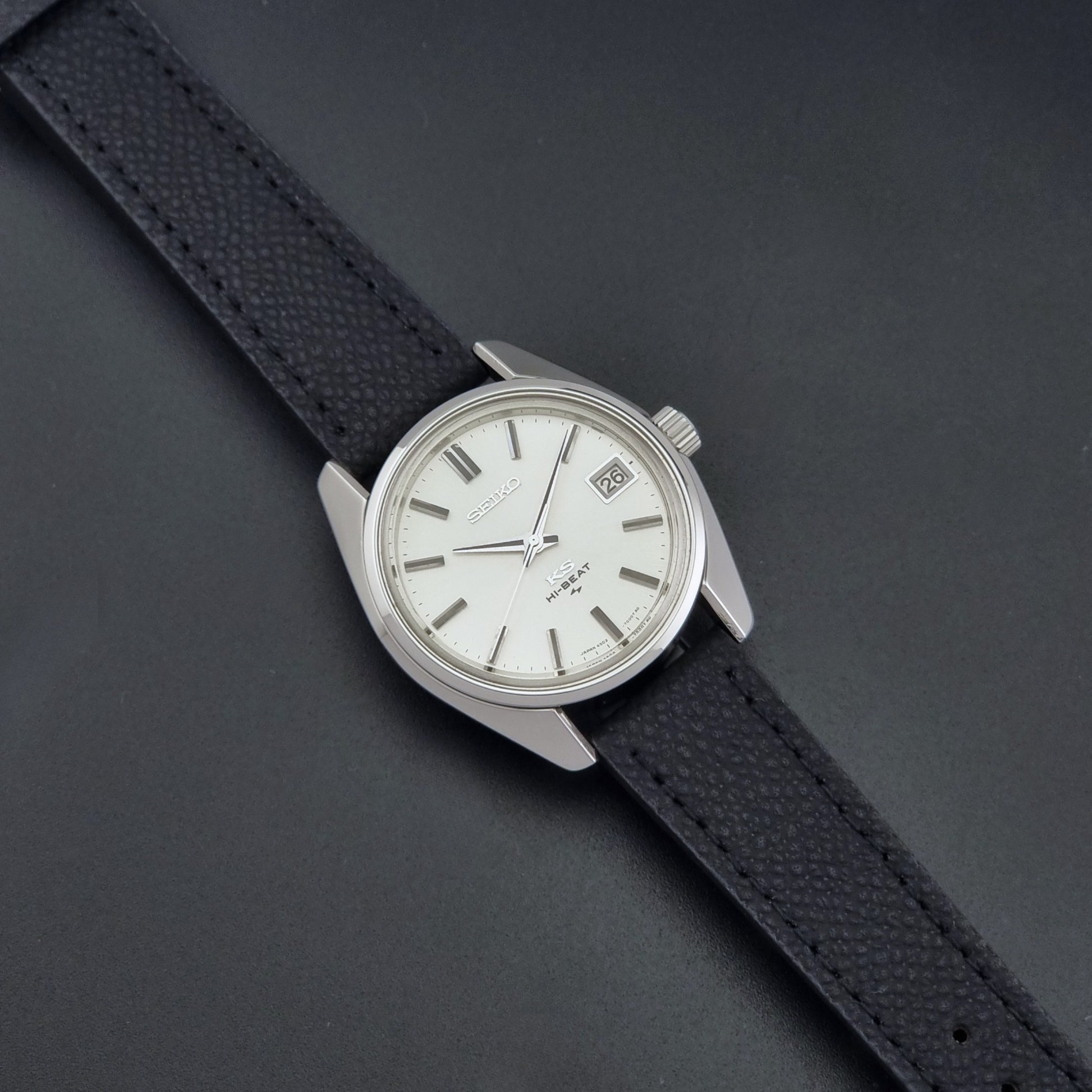 Vintage King Seiko 4502-7001 watch with black strap and silver case on a dark gray background dial