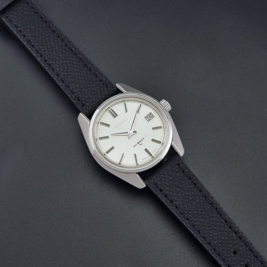 Vintage King Seiko 4502-7001 watch with black strap and silver case on a dark gray background dial