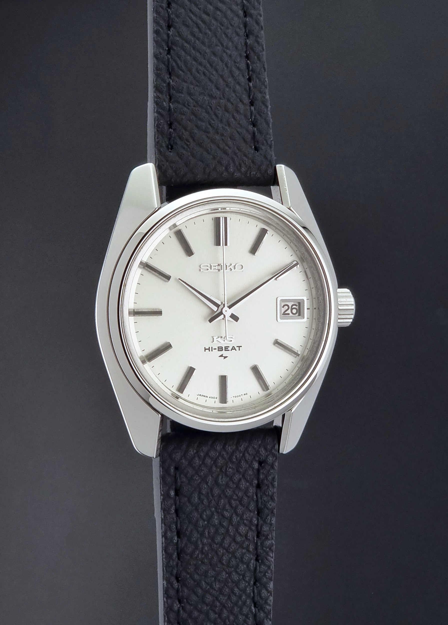 Vintage King Seiko 4502-7001 watch with black strap and silver case on a dark gray background side profile view
