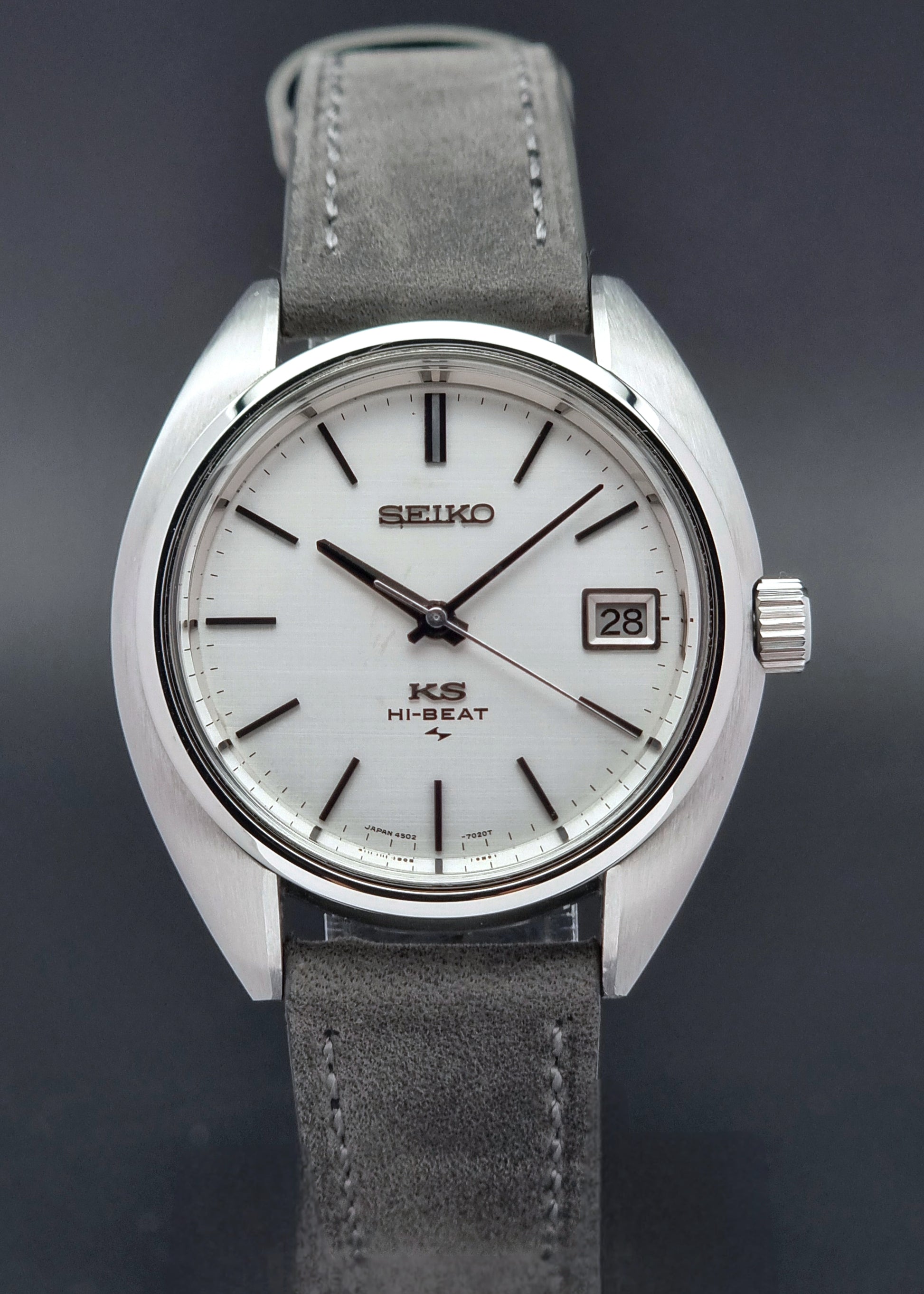 Vintage King Seiko Wristwatch 4502-7010 with gray strap and silver case on a wooden surface close front view
