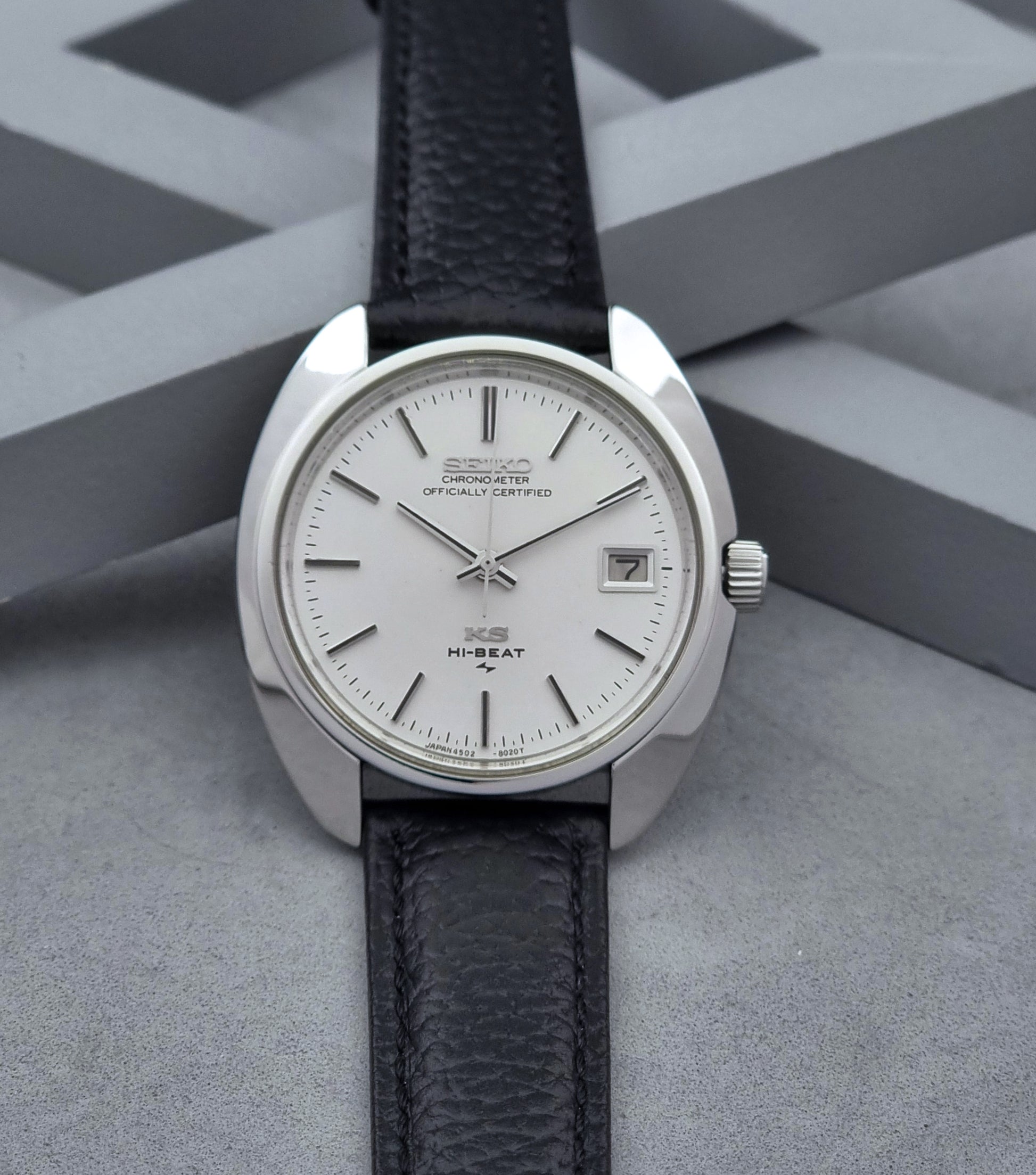 Vintage King Seiko Wristwatch 4502-8010 with black leather strap on a gray background dial view