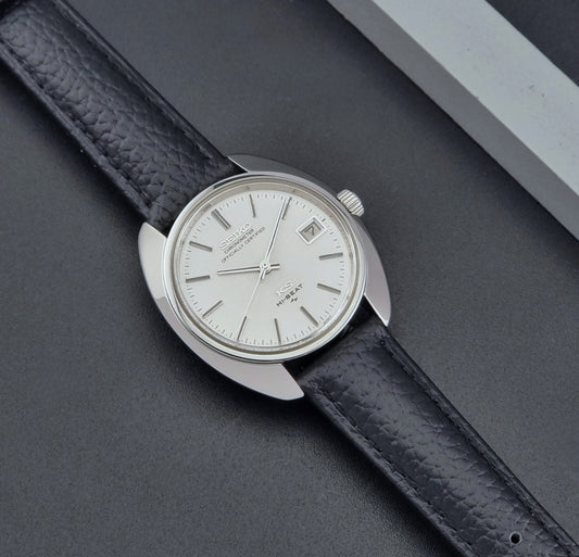 Vintage King Seiko Wristwatch 4502-8010 with black leather strap on a gray background dial